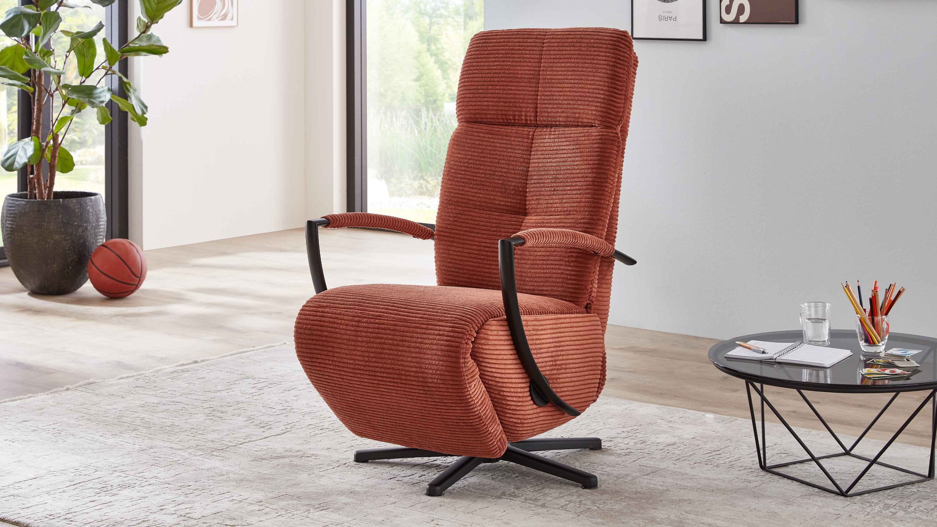 Relaxsessel mit kupferfarbenem Breitcordbezug und mattschwarzem Sternfuß in modernem Wohnzimmer