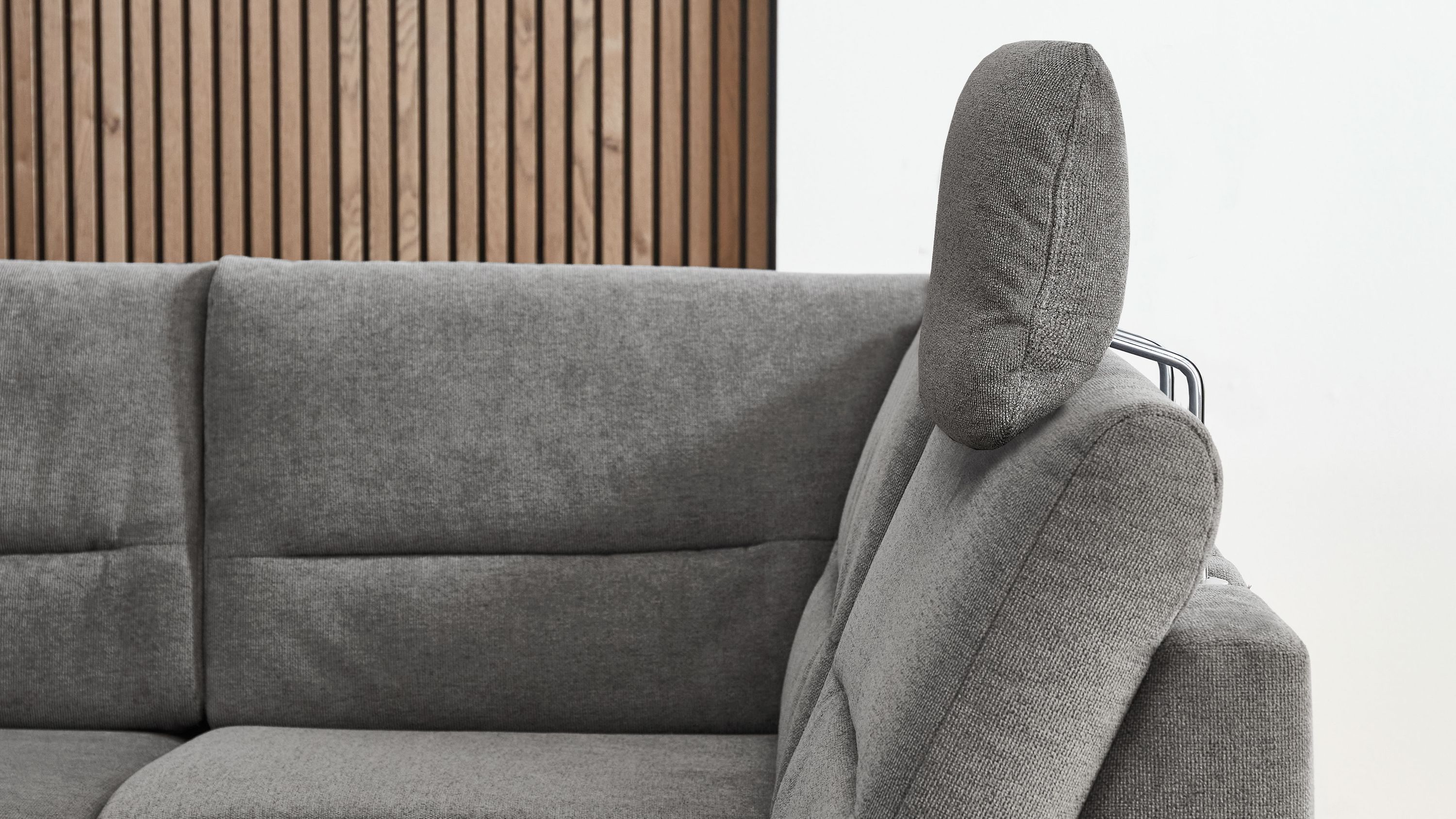 Graue Kopfstütze aus Flachgewebe auf grauem Sofa mit Metallgestell