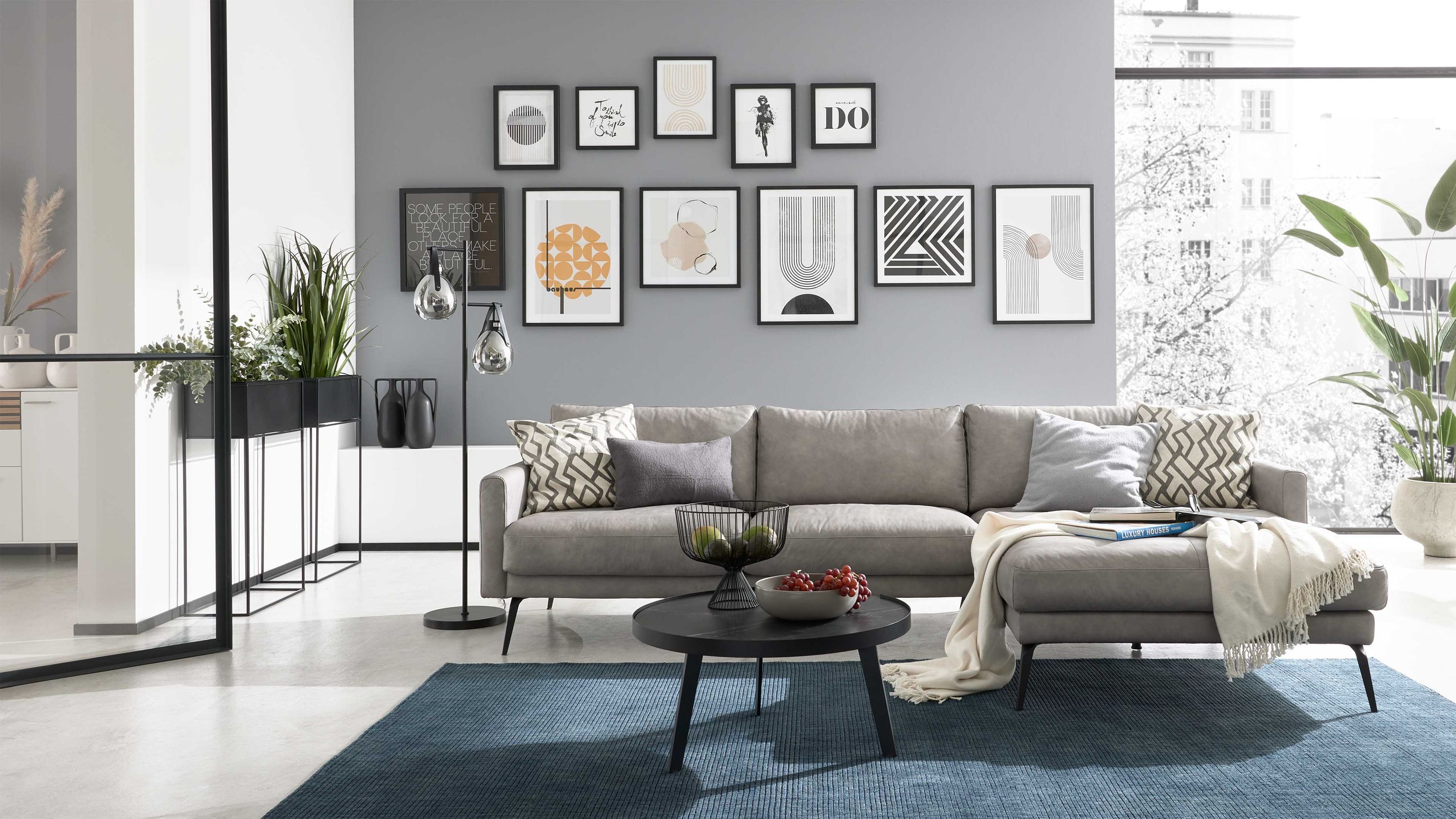 Ecksofa mit hellgrauem Bezug und Metallfüßen in modernem Wohnzimmer mit grauer Wand und Bildergalerie