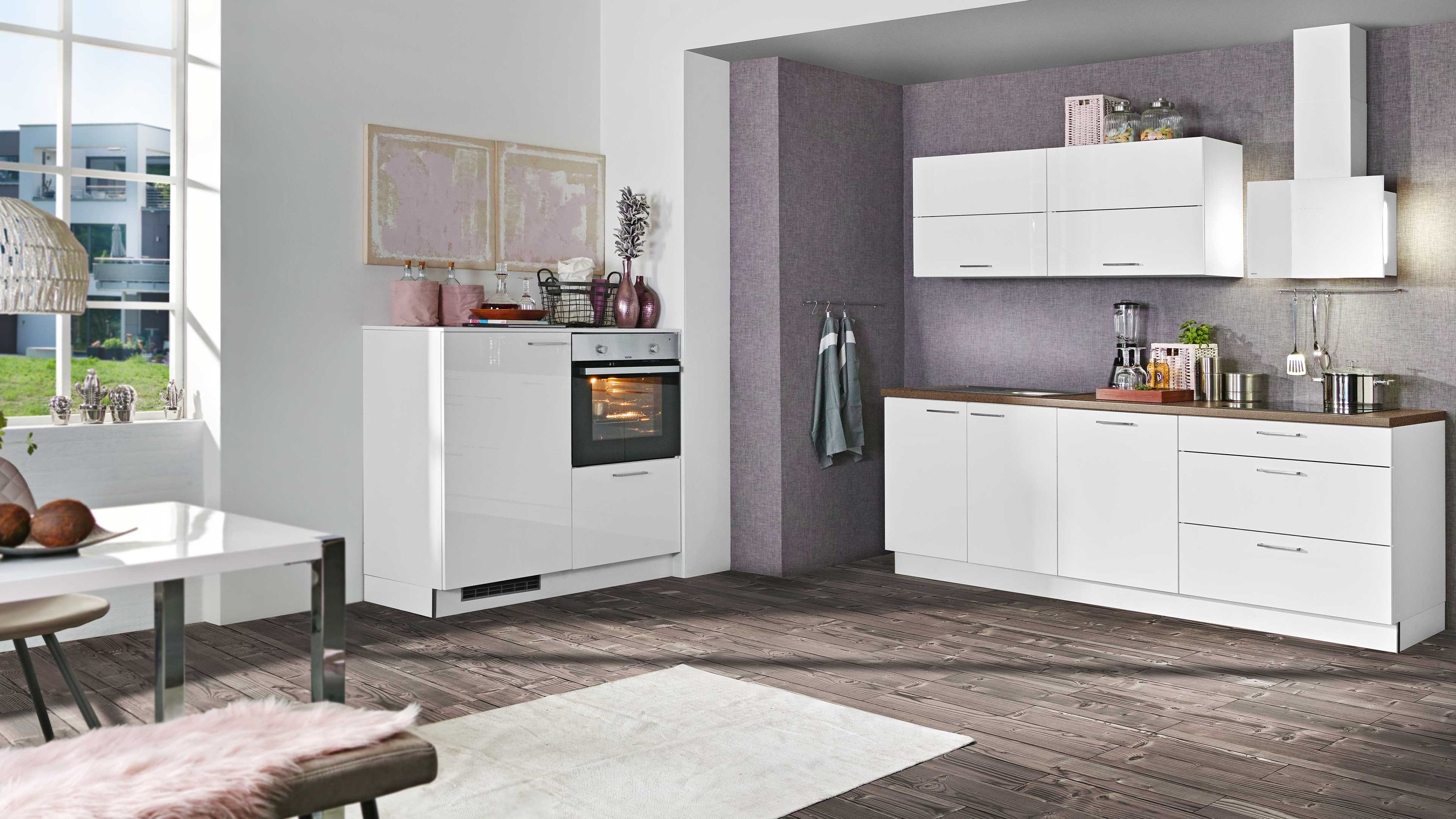 Helle Küche mit Einbaugeräten und dunklem Holzfußboden Küche mit weißen Schränken Einbauofen Kochbereich mit Dunstabzug dunklem Boden und Fensterlicht
