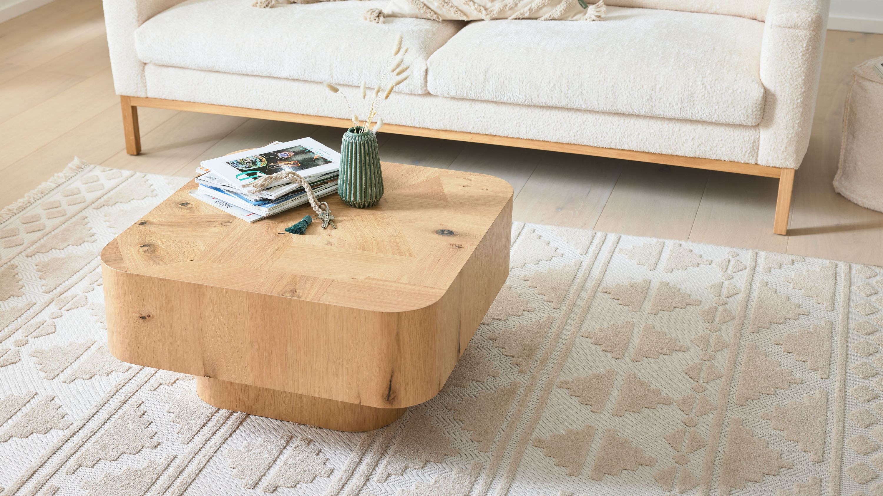 Quadratischer Couchtisch mit abgerundeten Ecken und Holzoptik auf Teppich vor Sofa