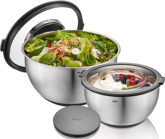 Zwei Edelstahlschalen mit Deckel, eine mit Salat, die andere mit Joghurt und Beeren, schräg von oben aufgenommen.