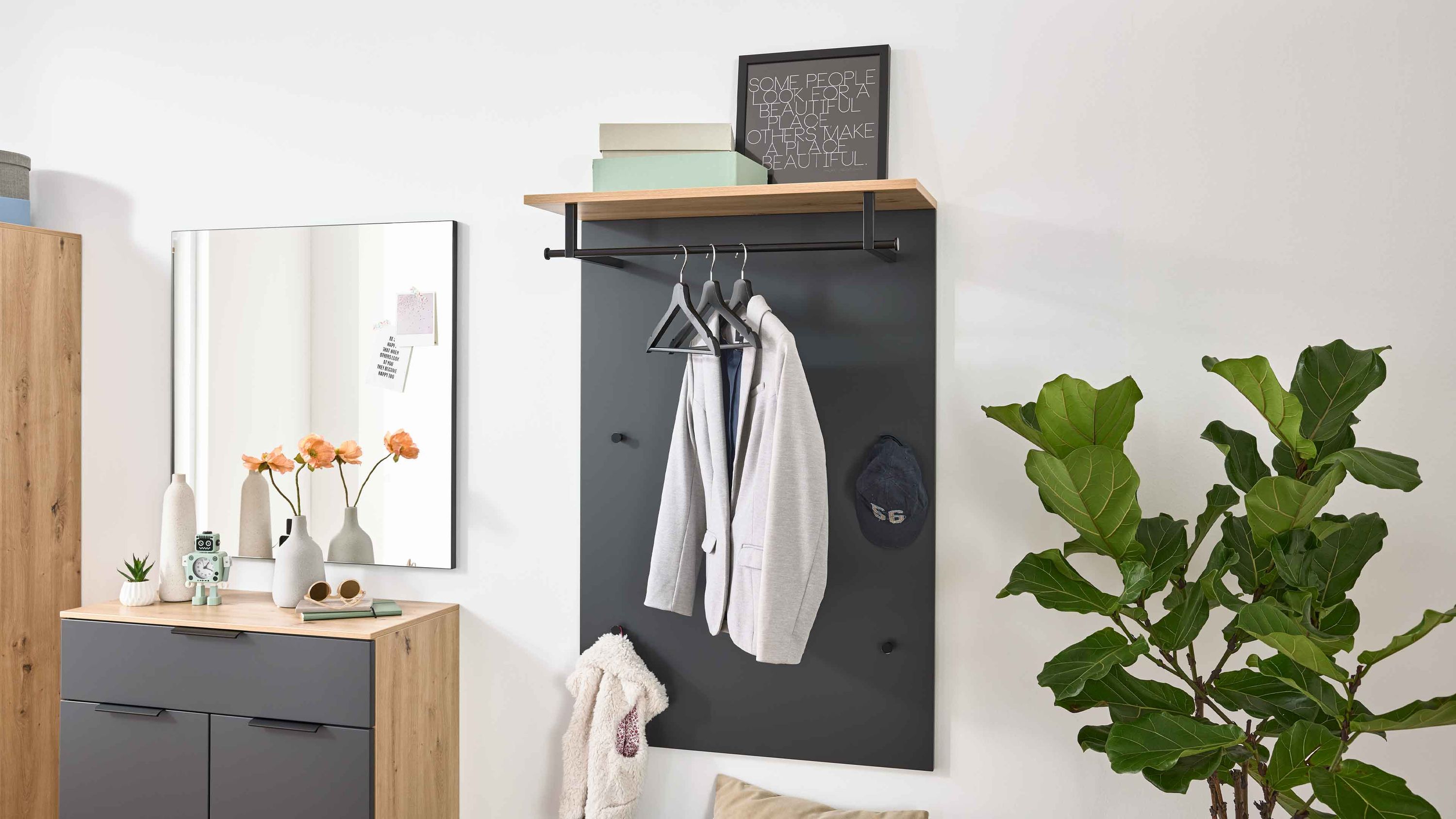Wandgarderobe mit anthrazitfarbener Rückwand Holzablage oben Kleiderstange und mehreren Haken mit Jacke und Hut