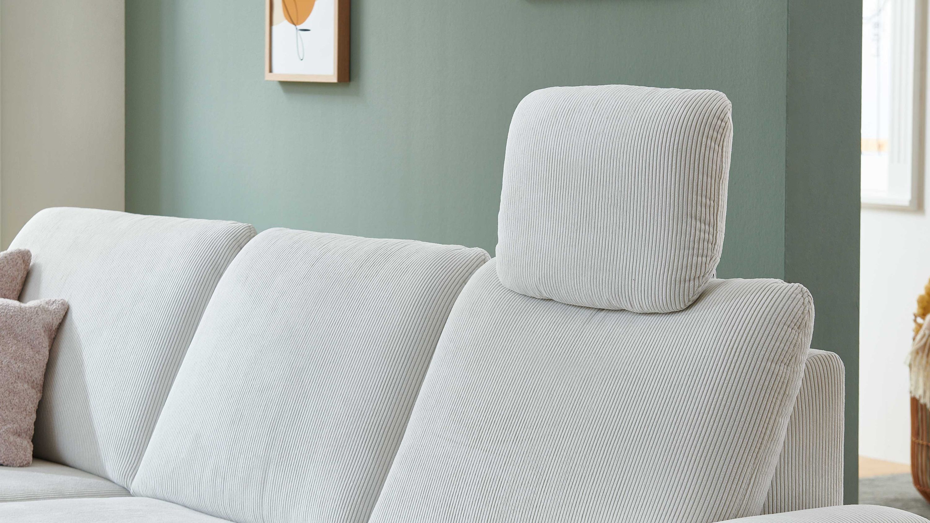 Naturweiße Kopfstütze aus Feincord auf einem hellen Sofa mit Rückenlehnen
