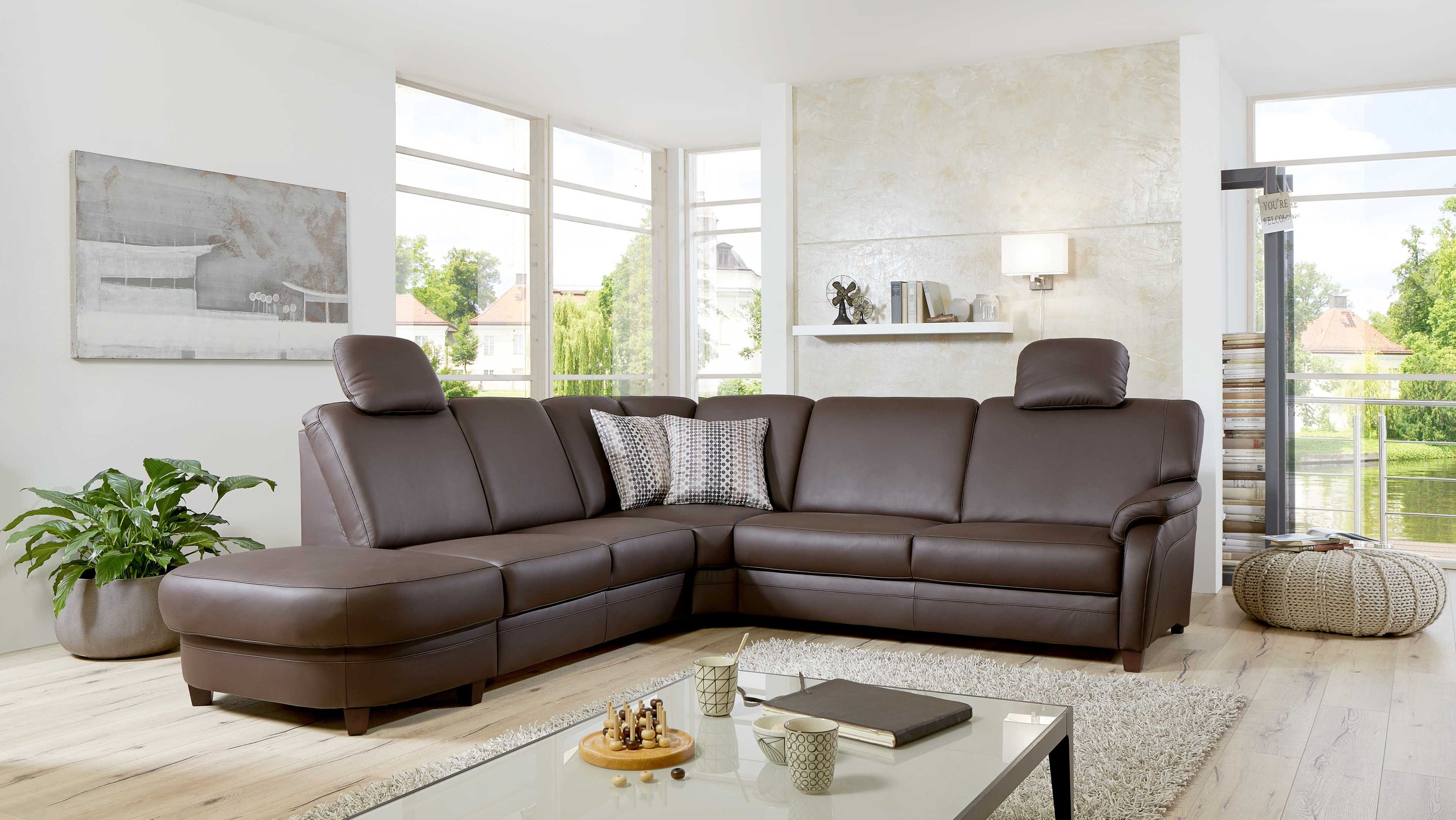 Ecksofa mit espressofarbenem Lederbezug und verstellbaren Kopfstützen in modernem Wohnzimmer