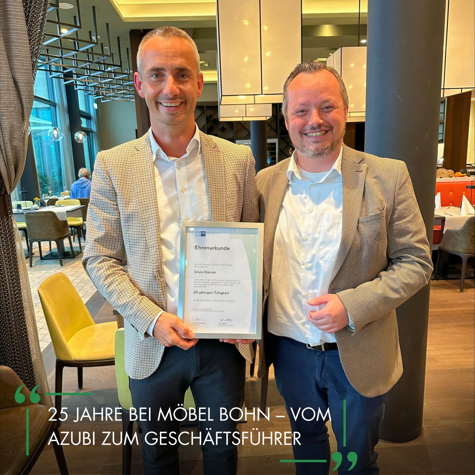 Rösner und Lehr in Anzügen halten eine Ehrenurkunde für 25 Jahre Betriebszugehörigkeit bei Möbel Bohn.