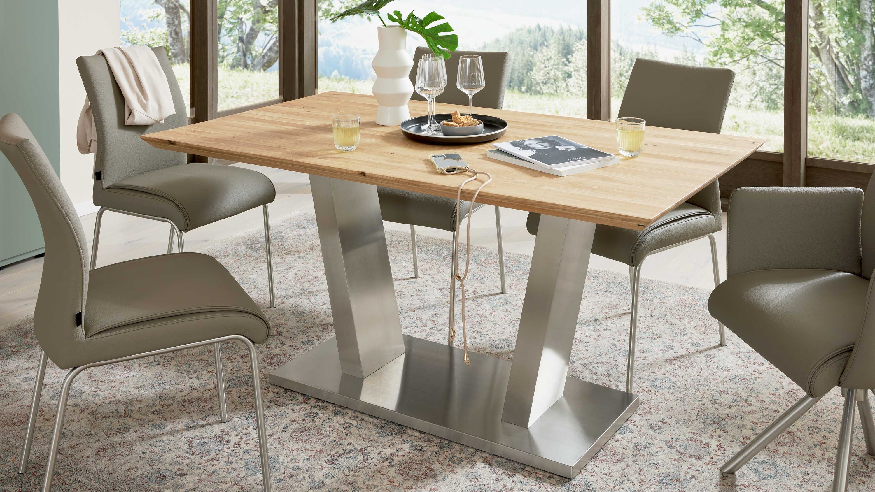 Rechteckiger Esstisch mit Holzplatte und zwei breiten Metallbeinen auf rechteckiger Metallplatte