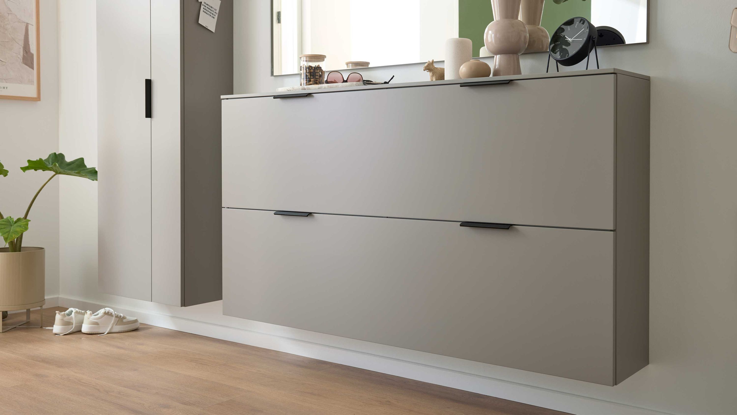 Hänge-Schuhschrank mit zwei Klappen in graubeigem Mattlack an weißer Wand