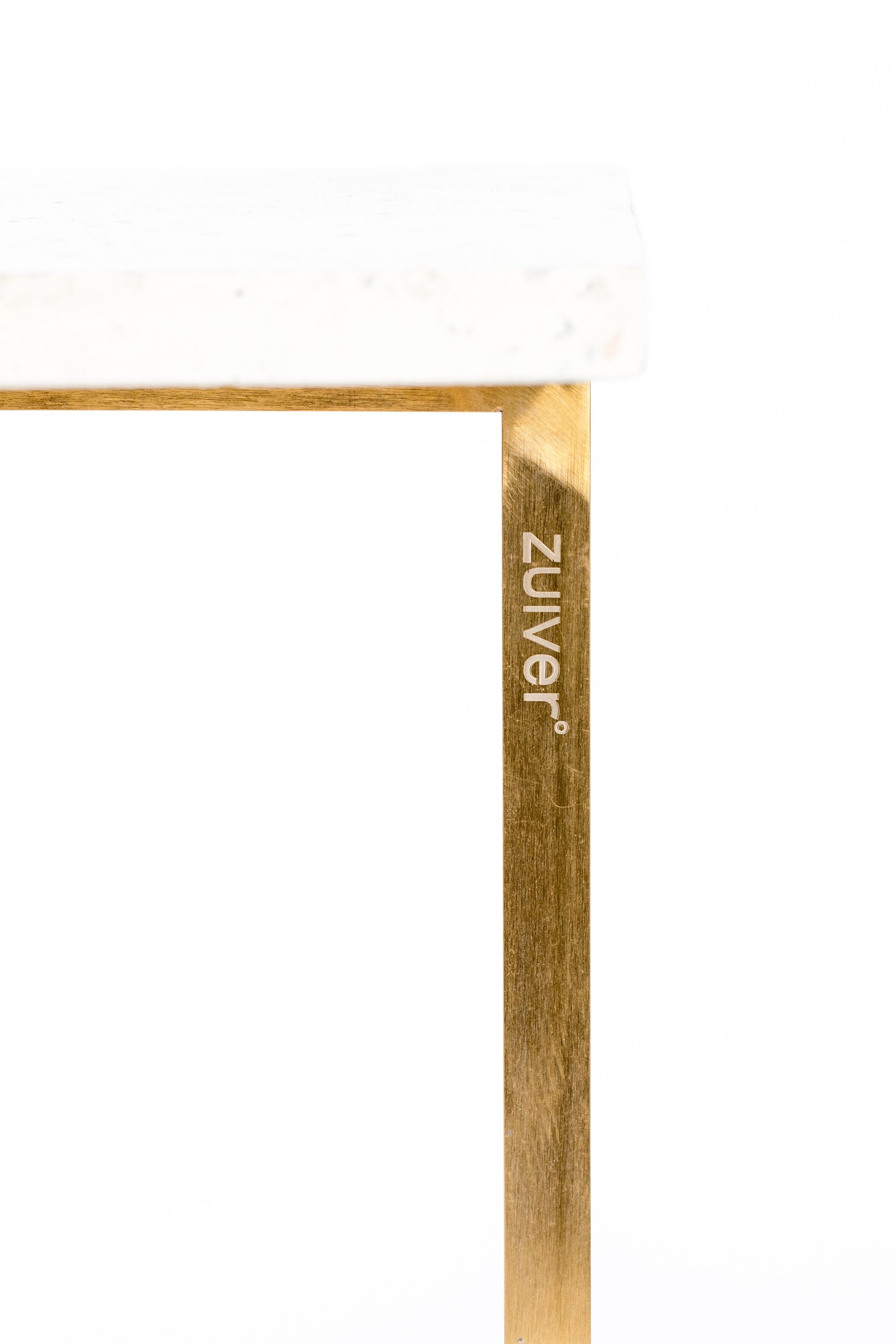 Goldene Tischkante Ein kleiner Teil eines Tisches mit goldener Ecke ist sichtbar, Nahaufnahme vor hellem Hintergrund.