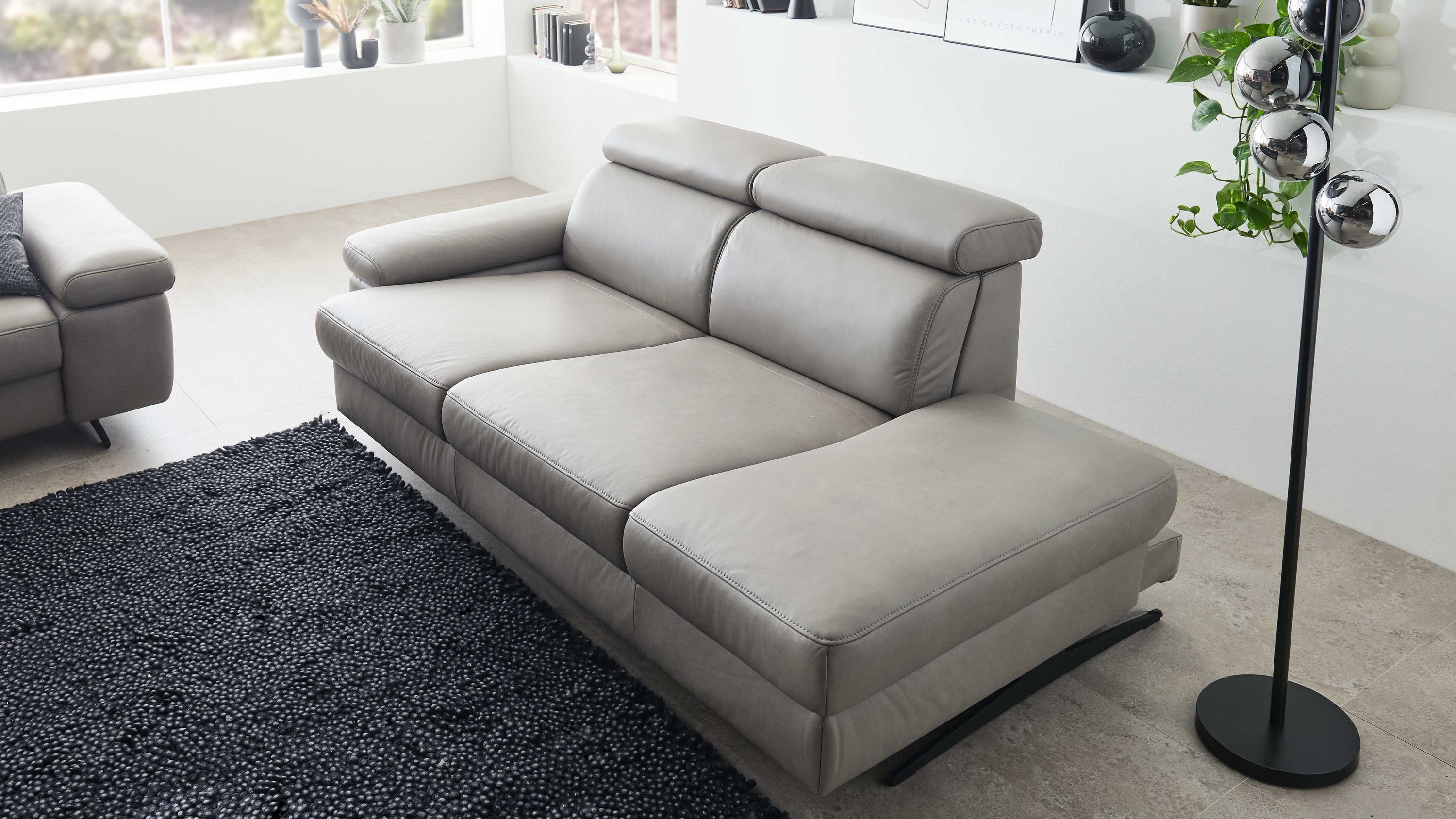 Recamiere mit zwei Kopfstützen und Metallkufen in grauer Farbe in modernem Wohnzimmer