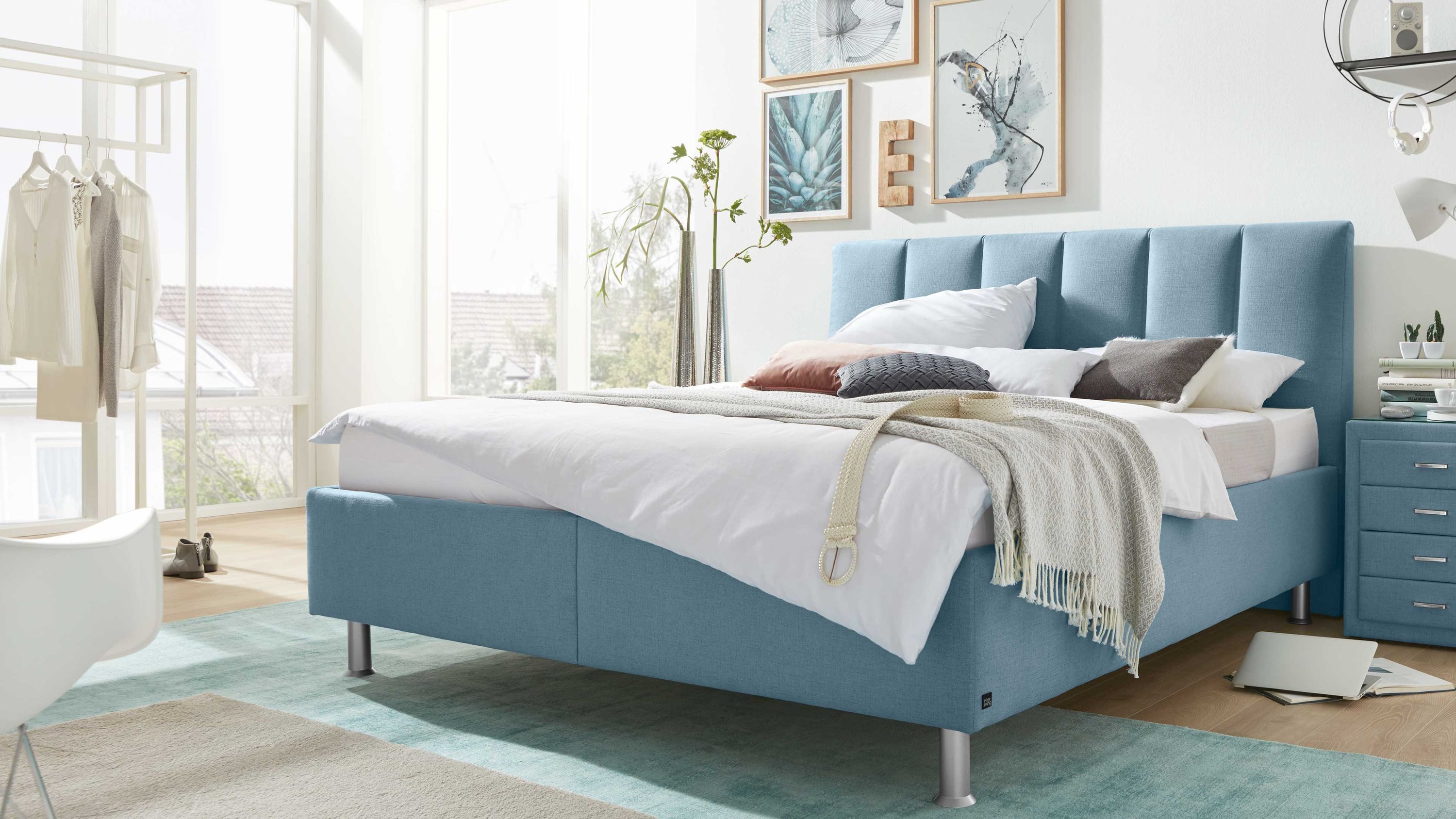 Polsterbett mit rechteckigem gestepptem Kopfteil und türkisem Bezug in modernem Schlafzimmer