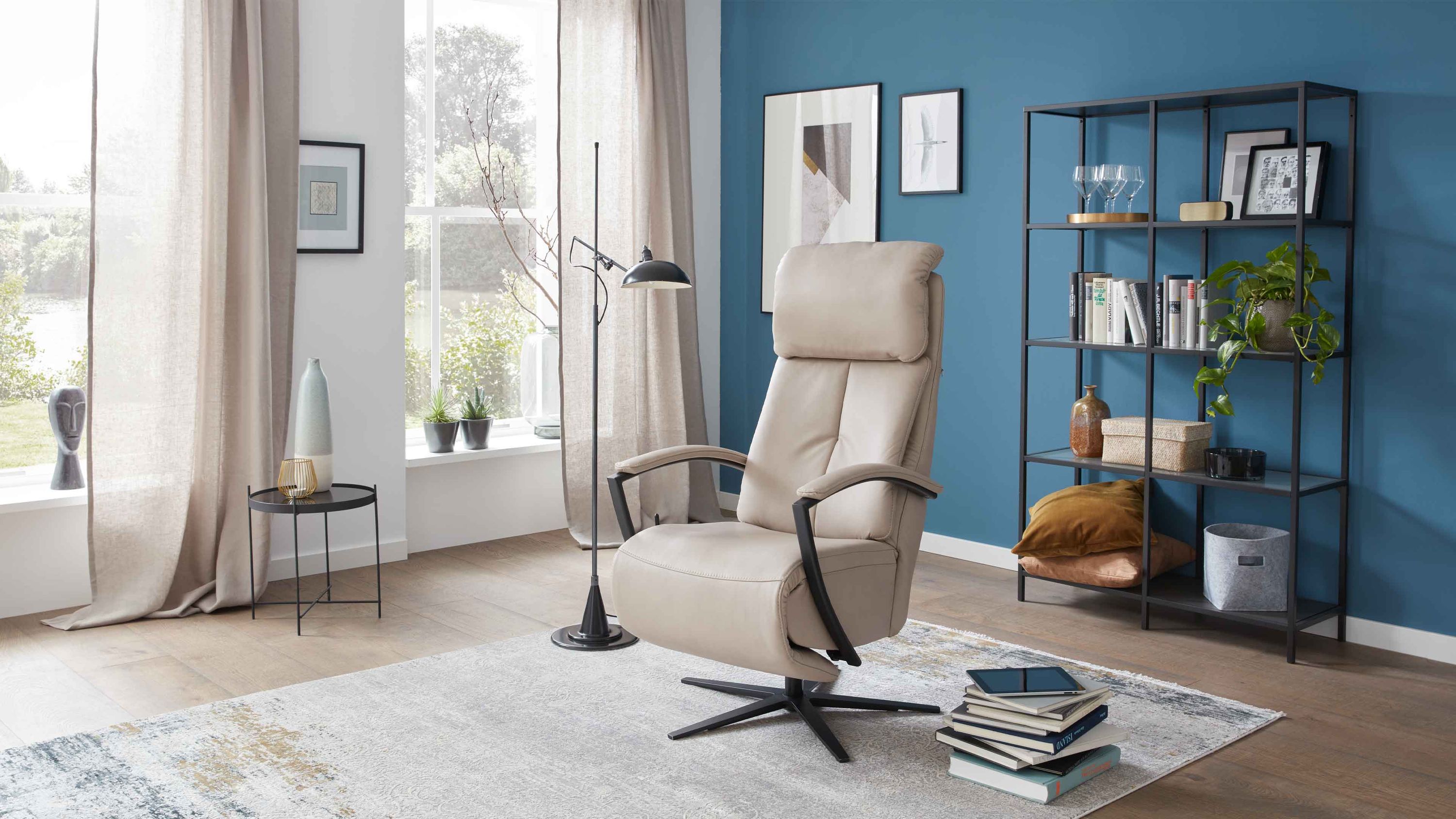 Beiger Relaxsessel mit hoher Rückenlehne und schwarzem Sternfuß in modernem Wohnzimmer