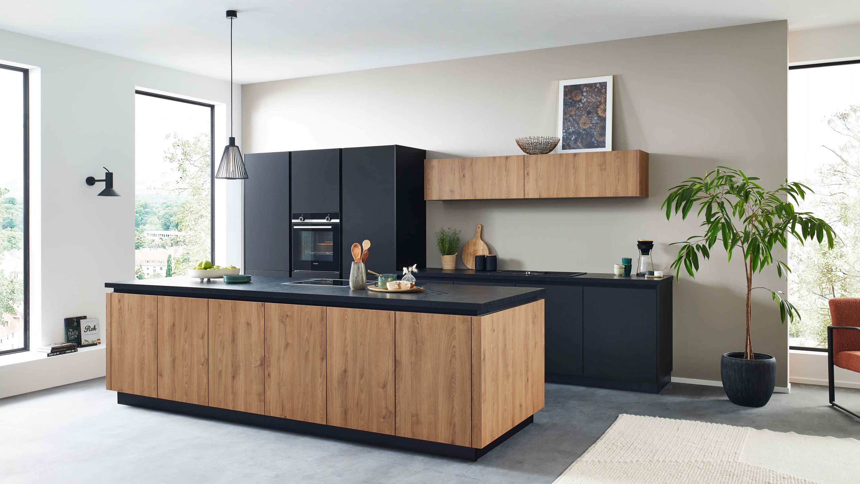 Moderne Inselküche in Schwarz mit Holzfronten Hängeschrank schwarzer Arbeitsplatte und hellem Raumambiente.