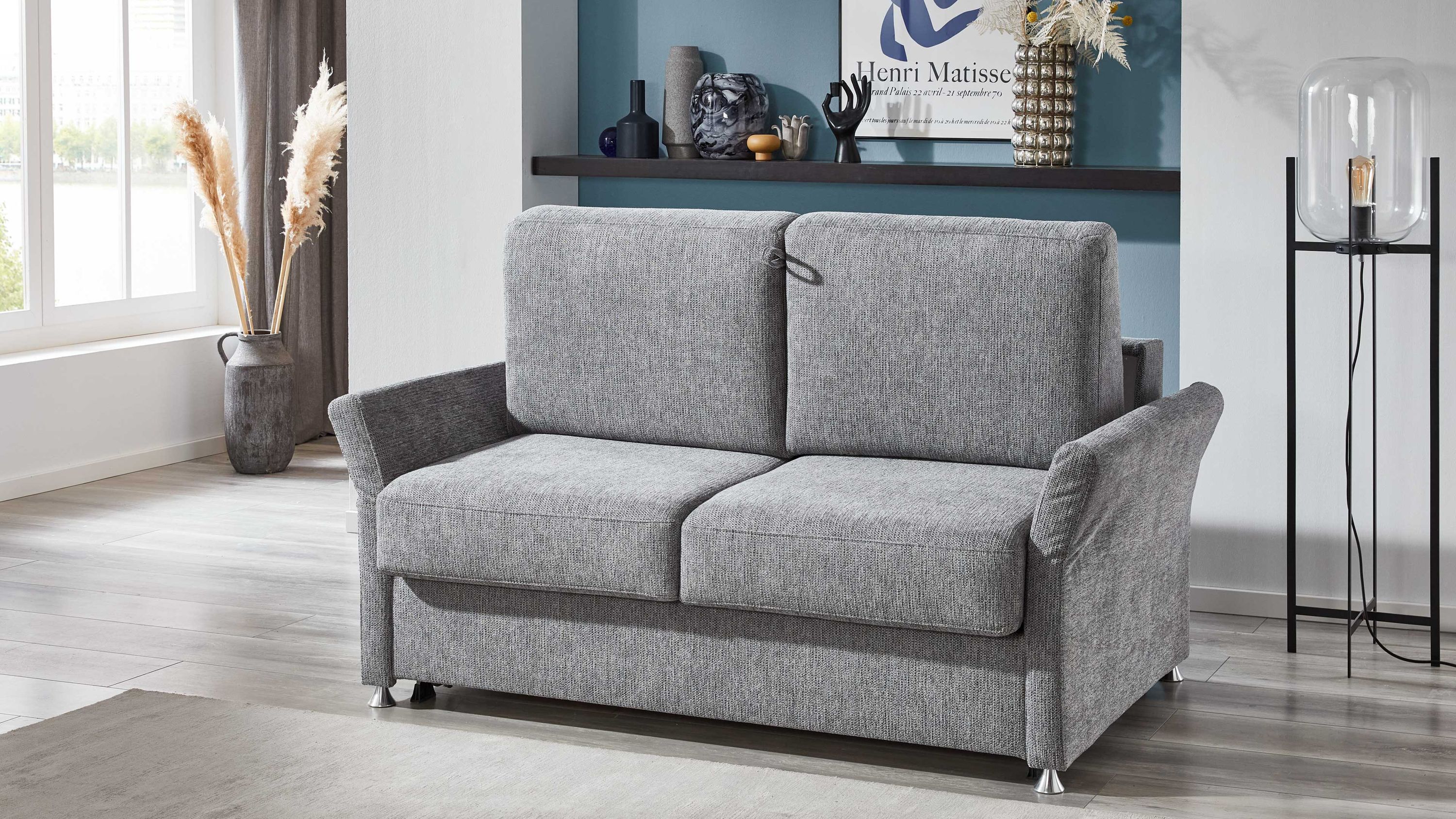 Zweisitziges Schlafsofa mit grauem Webstoffbezug und Chromfüßen in modernem Wohnzimmer