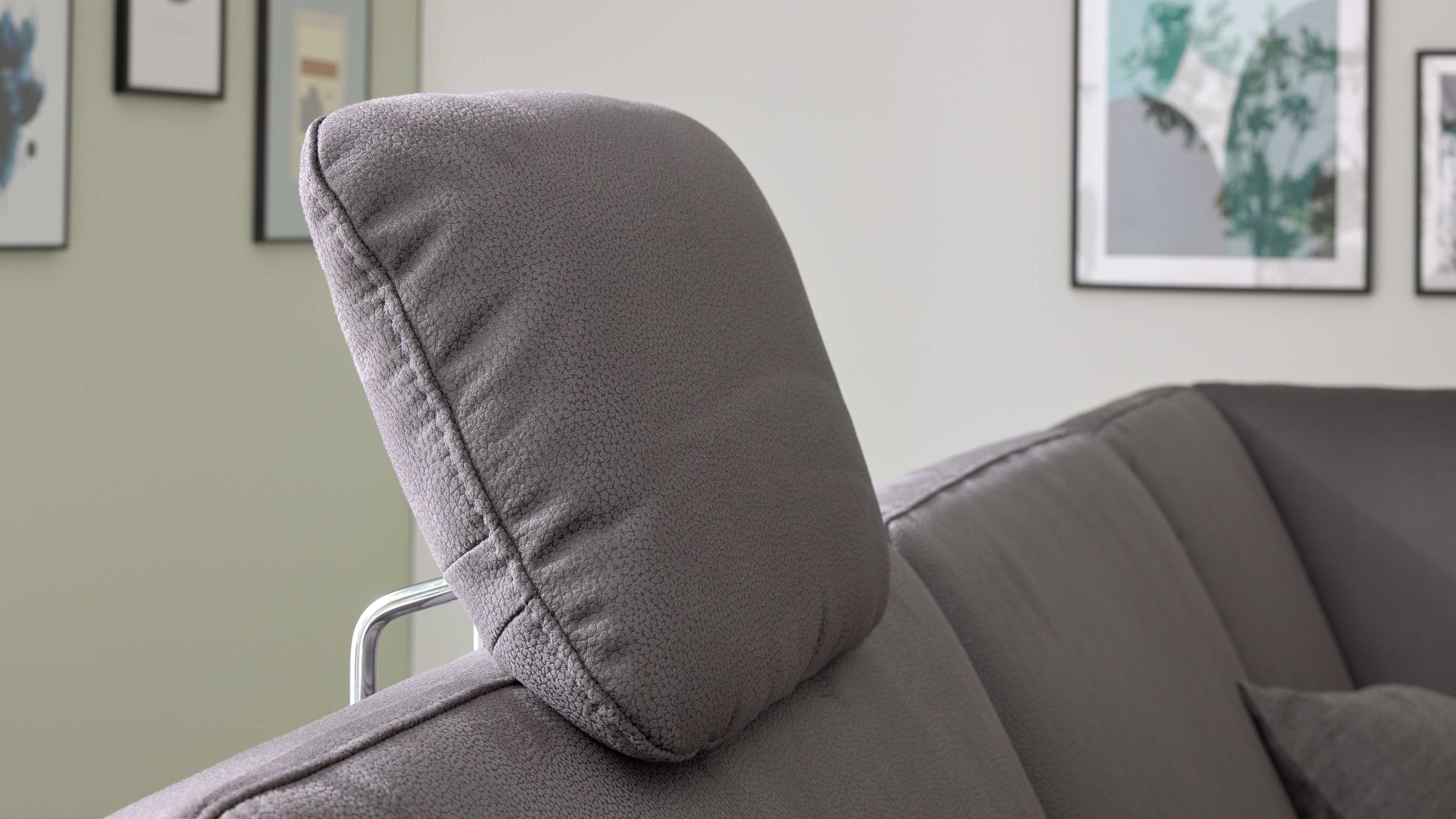 Kopfstütze aus Mikrofaser auf Sofa Stahlfarbene Kopfstütze aus Mikrofaser auf grauem Sofa mit Metallhalterung