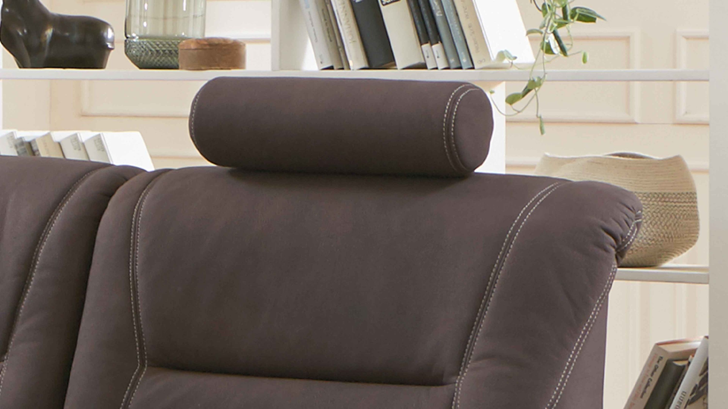 Braune Kopfstütze in runder Form auf einem Polstersofa mit sichtbaren Nähten