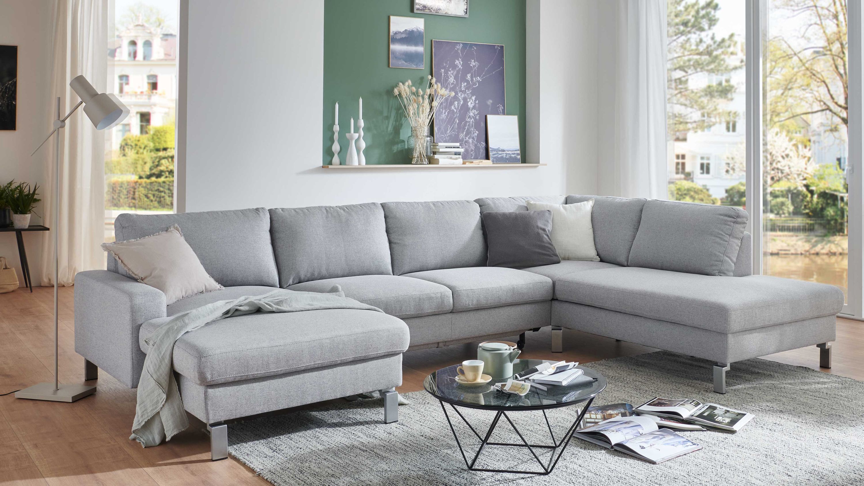 Hellgraues Ecksofa mit Flachgewebe Metallfüßen und mehreren Kissen in modernem Wohnzimmer