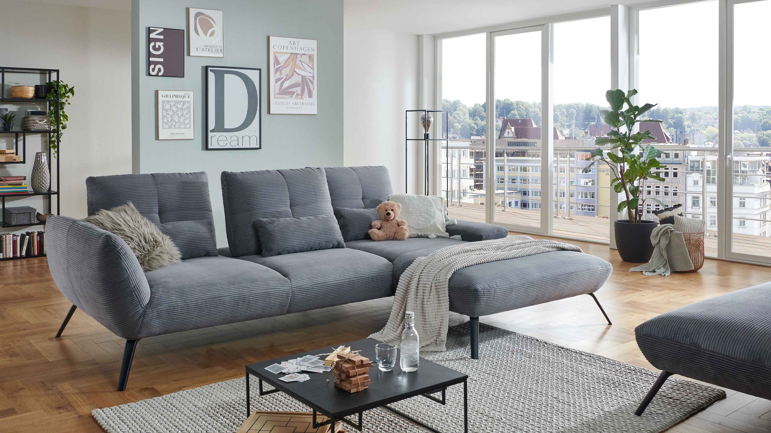 Ecksofa mit grauem Cordbezug und schwarzen Metallbeinen in modernem Wohnzimmer
