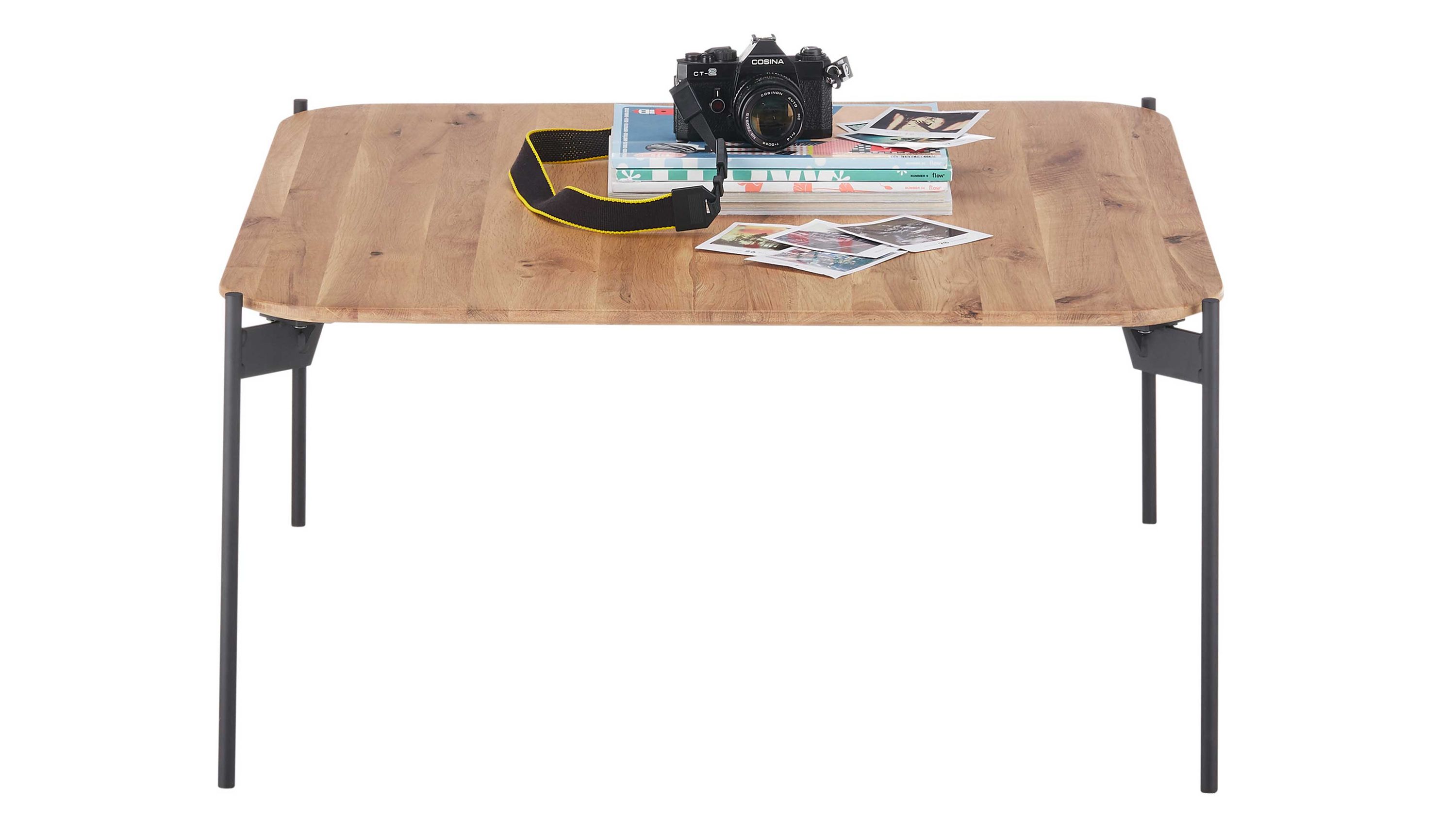 Quadratischer Couchtisch mit Holzplatte und schwarzen Beinen Quadratischer Couchtisch mit hellem Holzplattenblatt und schwarzen Metallbeinen darauf Kamera und Zeitschriften