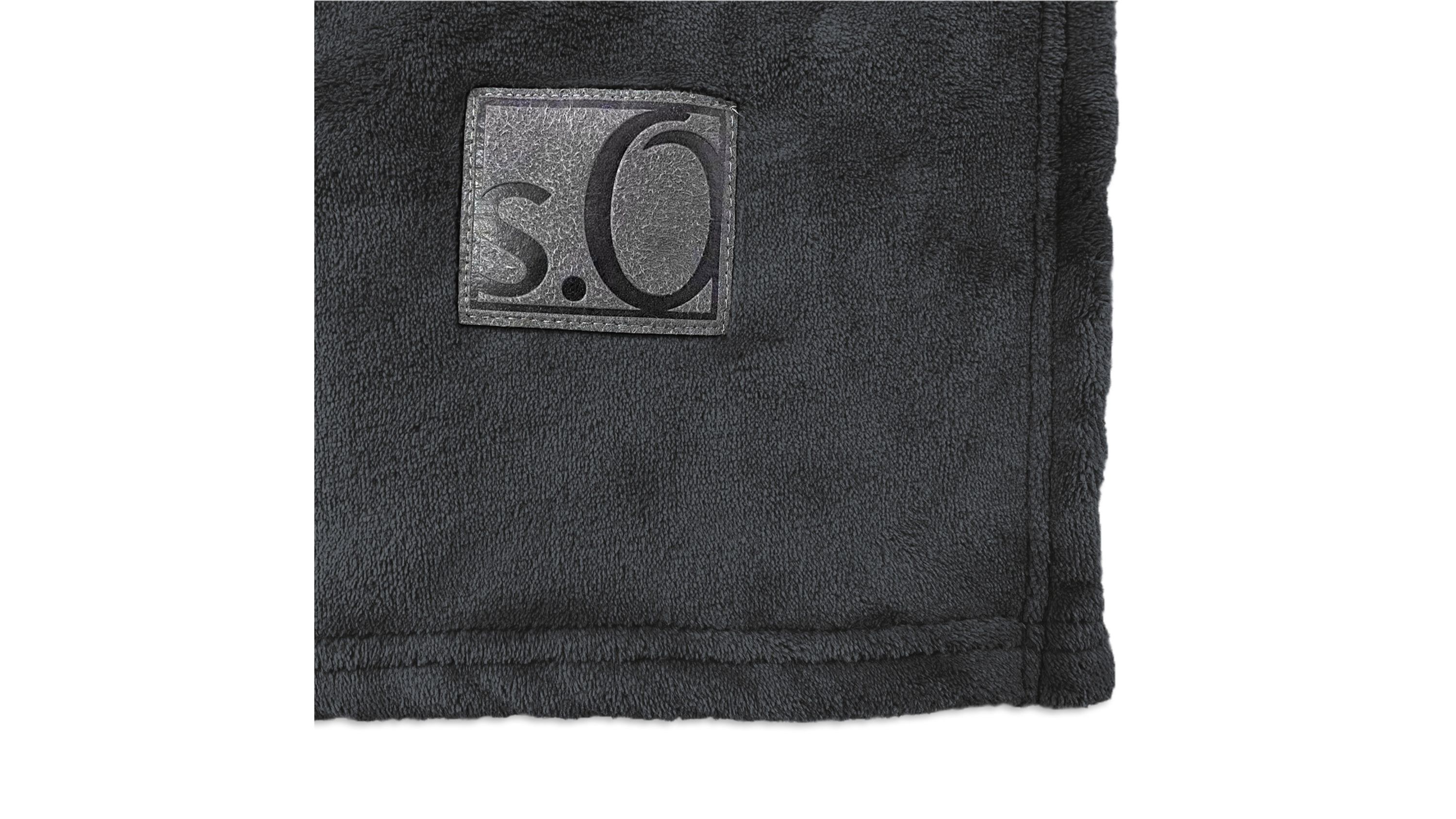 Schwarze Wohndecke mit weicher Oberfläche und eckigem Logoaufnäher