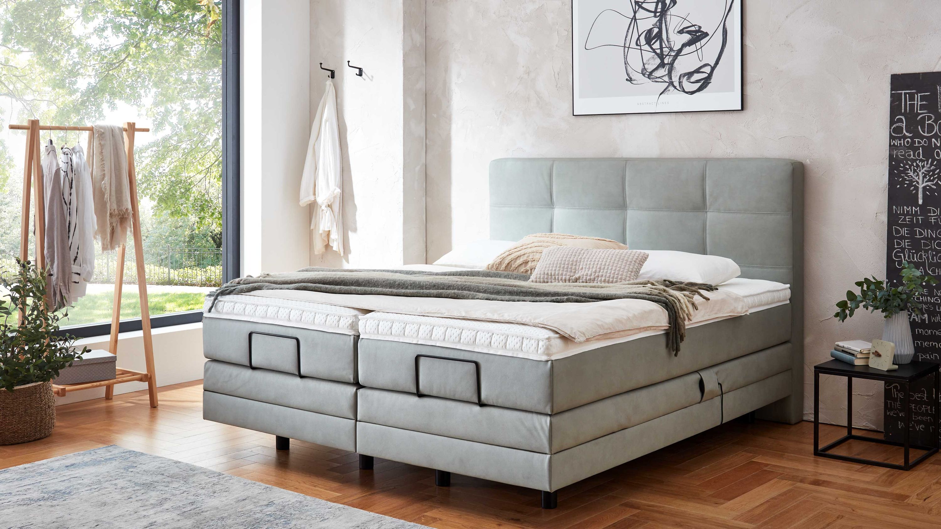 Boxspringbett mit gepolstertem Kopfteil und jadefarbenem Bezug in modernem Schlafzimmer