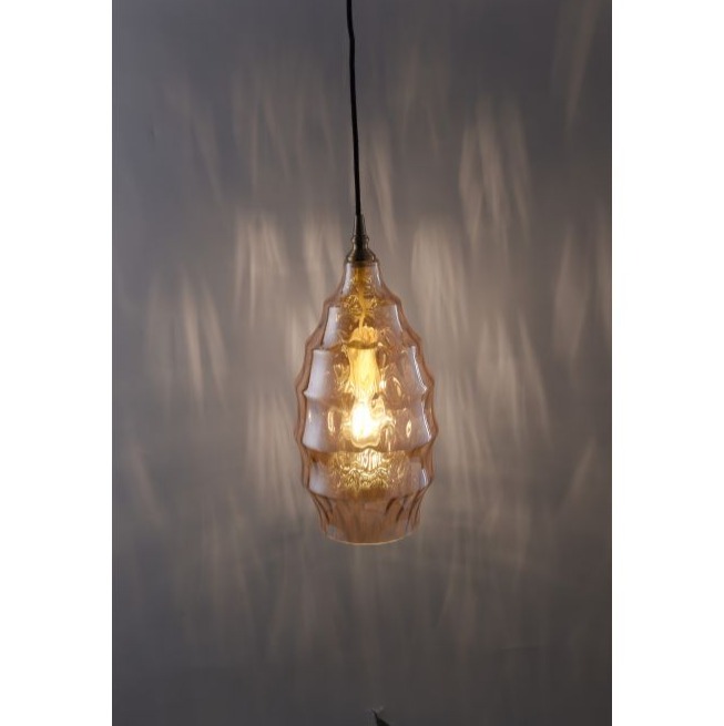 Pendelleuchte mit ovalem Glasschirm warmem Lichtschein und Reflexionen an der Wand leicht schräg fotografiert
