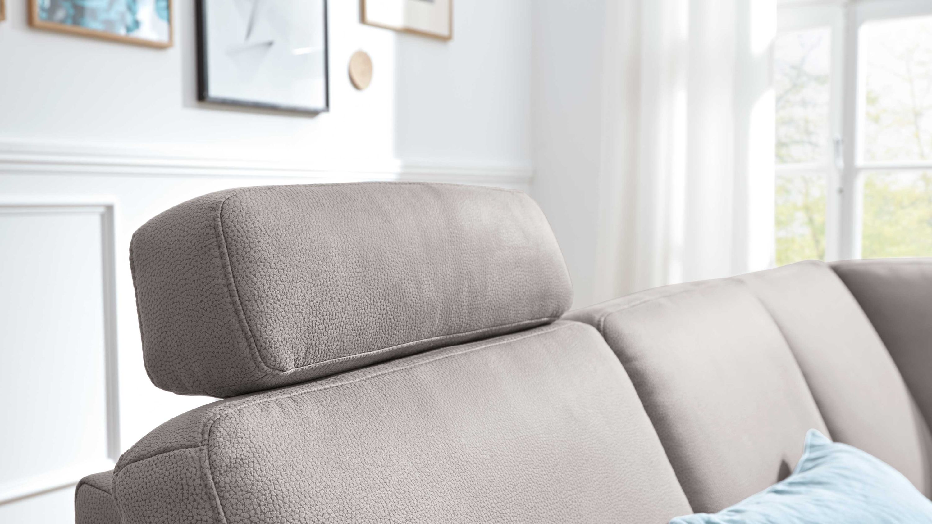 Kopfstütze aus Mikrofaser auf Sofa Alufarbene Kopfstütze aus Mikrofaser auf hellgrauem Sofa in hellem Raum