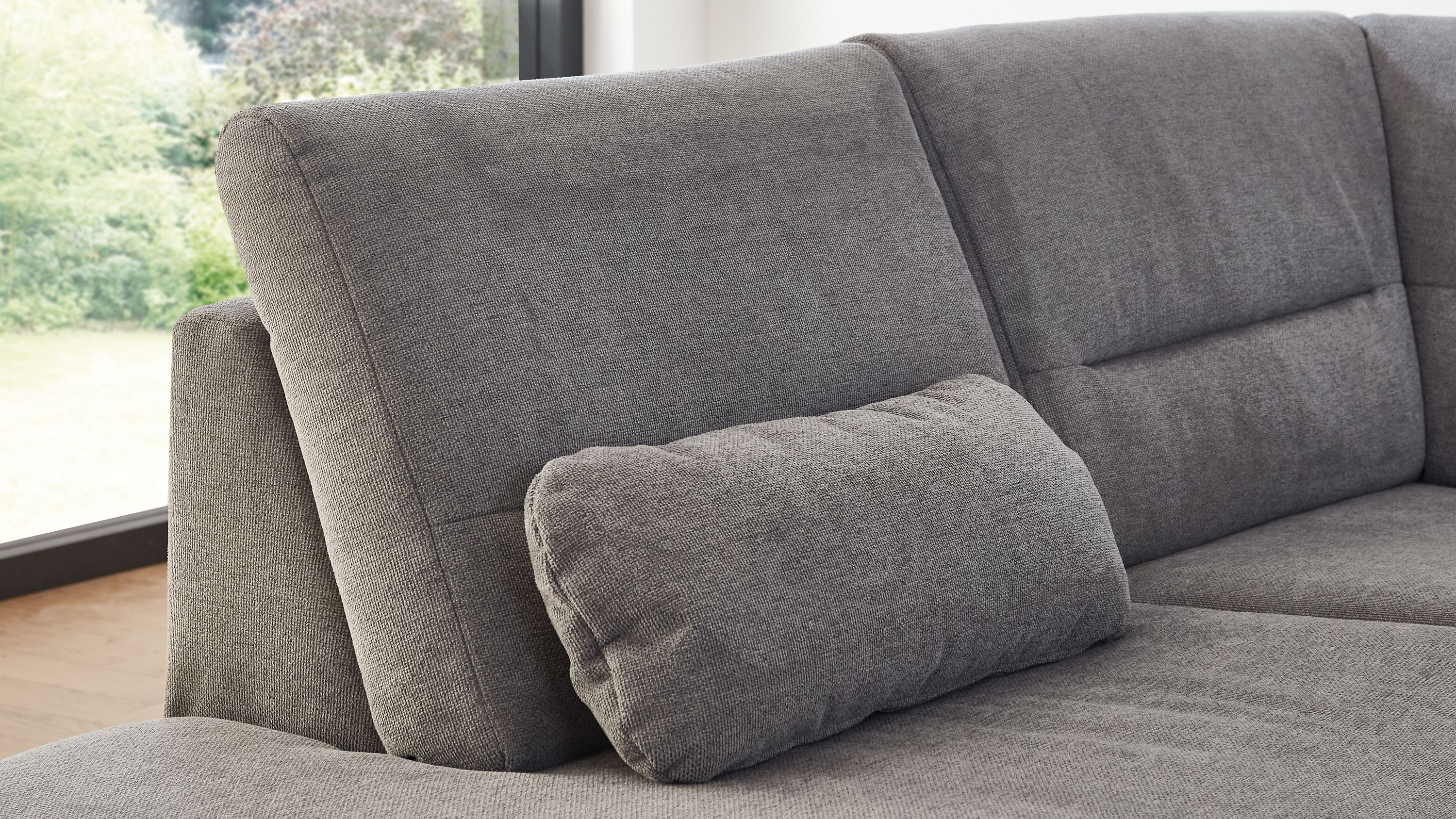 Graues Nierenkissen aus Flachgewebe auf grauem Sofa mit Rückenlehne