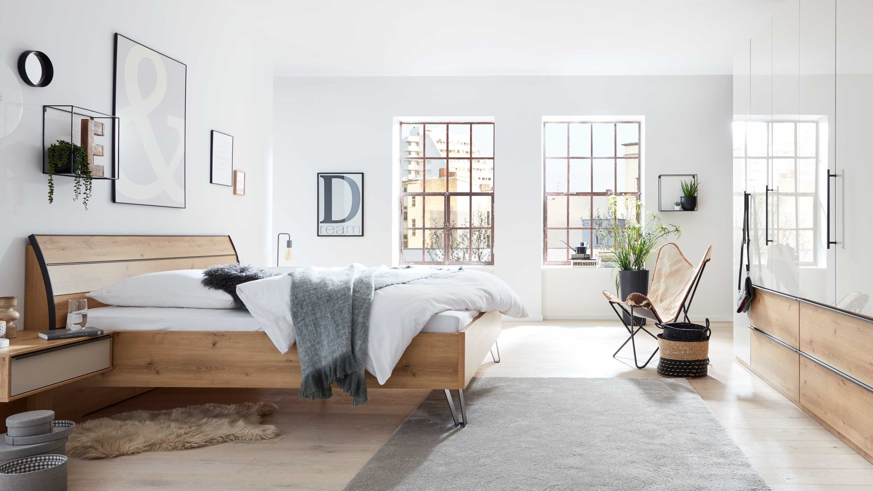 Schwebendes Bettgestell mit Kopfteil in Holzoptik und Metallbeinen in modernem Schlafzimmer