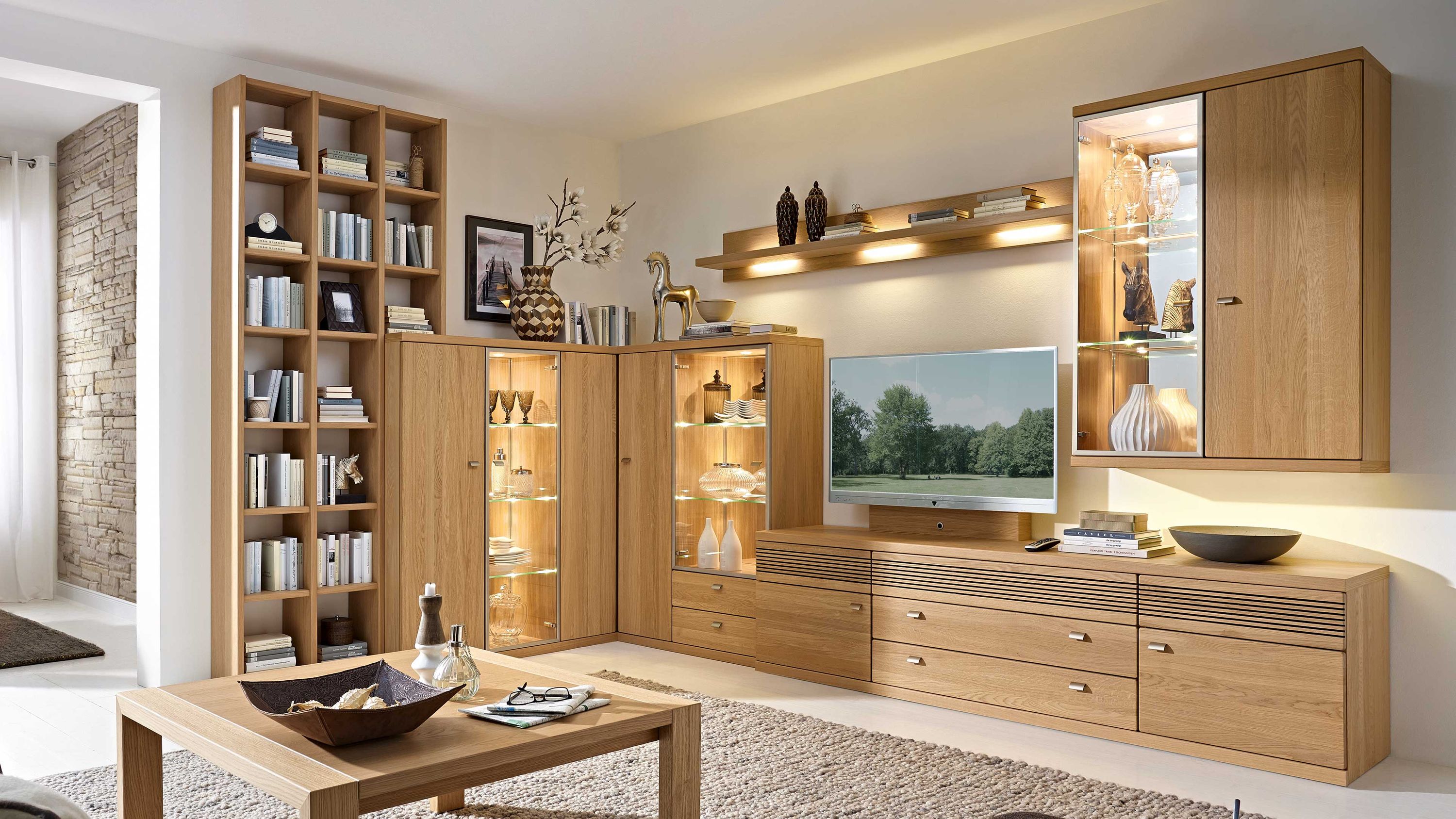 Eck-Wohnkombination aus hellem Holz mit Regalen und Vitrinen Eck-Wohnkombination aus hellem Holz mit Regalen Vitrinen mit Beleuchtung Schubladen und Hängeschrank
