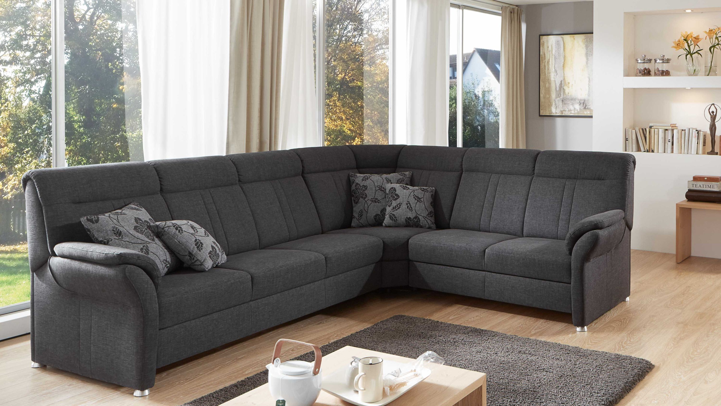 Anthrazitfarbenes Ecksofa mit Flachgewebe und Metallfüßen mit zwei gemusterten Kissen