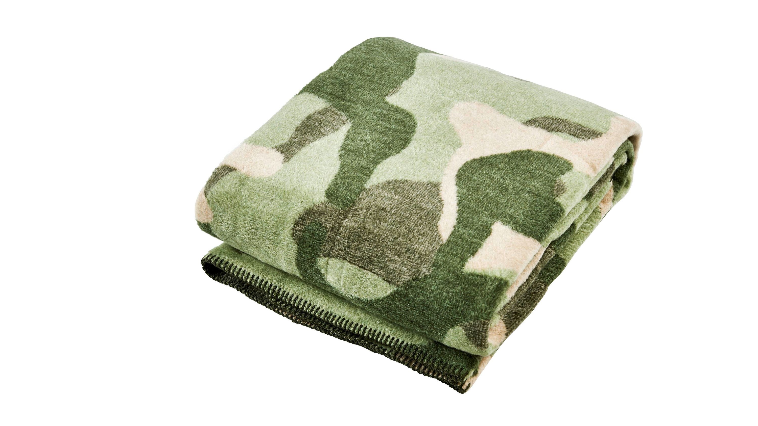 Gefaltete Wohndecke mit Camouflagemuster in verschiedenen Grüntönen und Beige