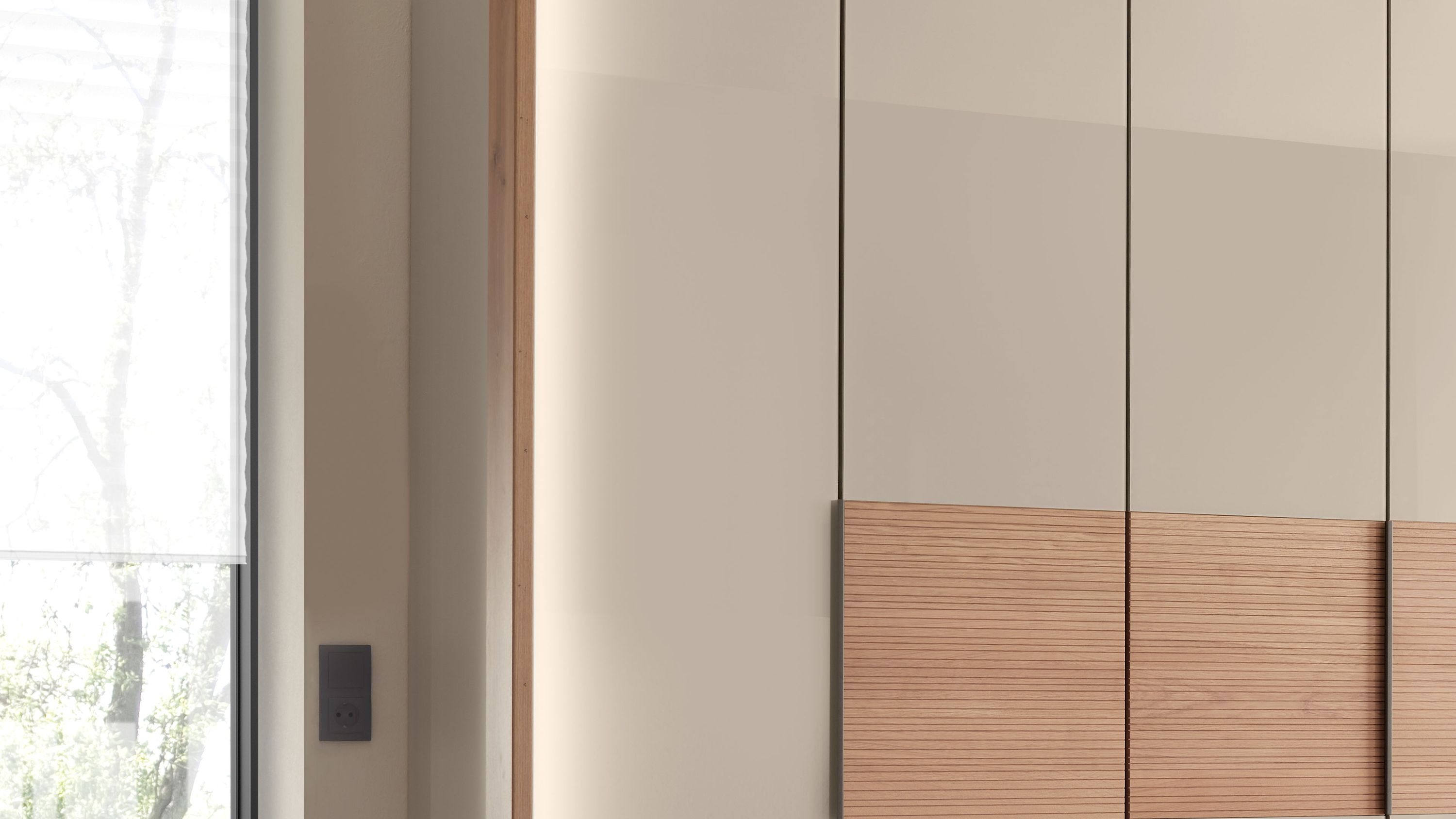 Schrankfront mit vertikaler Stollenbeleuchtung und glatten sowie gerillten Flächen in beige und holzfarben