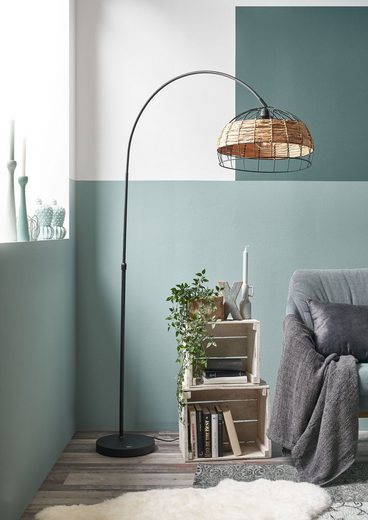 Schwarze Bogenlampe mit braunem Schirm in Grasoptik  geschwungen über Sofa in modernem Wohnambiente platziert