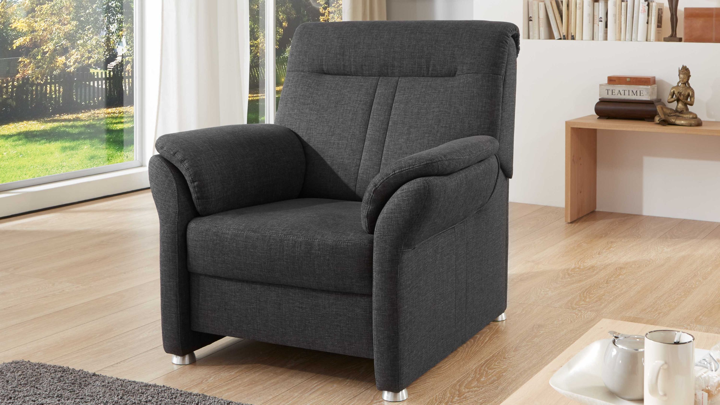 Polstersessel mit anthrazitfarbenem Flachgewebe und Metallfüßen in einem hellen Wohnzimmer