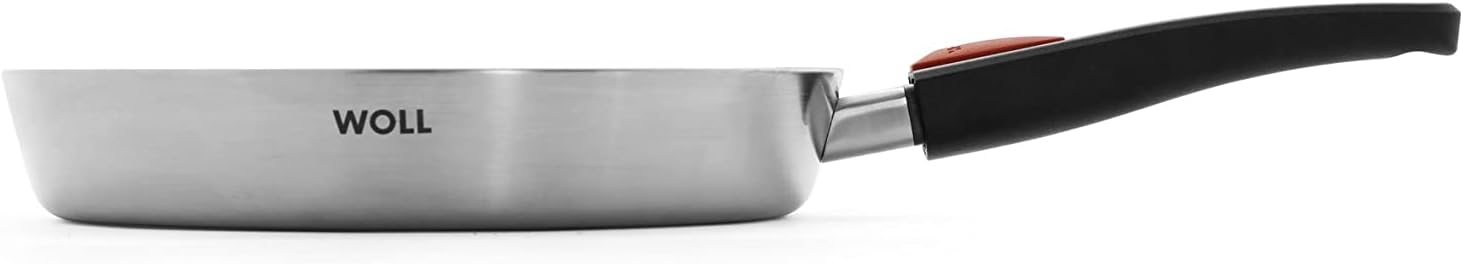 Woll Concept Pro Pfanne Seitenansicht mit Griff Seitenansicht einer Edelstahlpfanne mit glänzender Oberfläche und schwarzem, ergonomischem Griff mit rotem Knopf