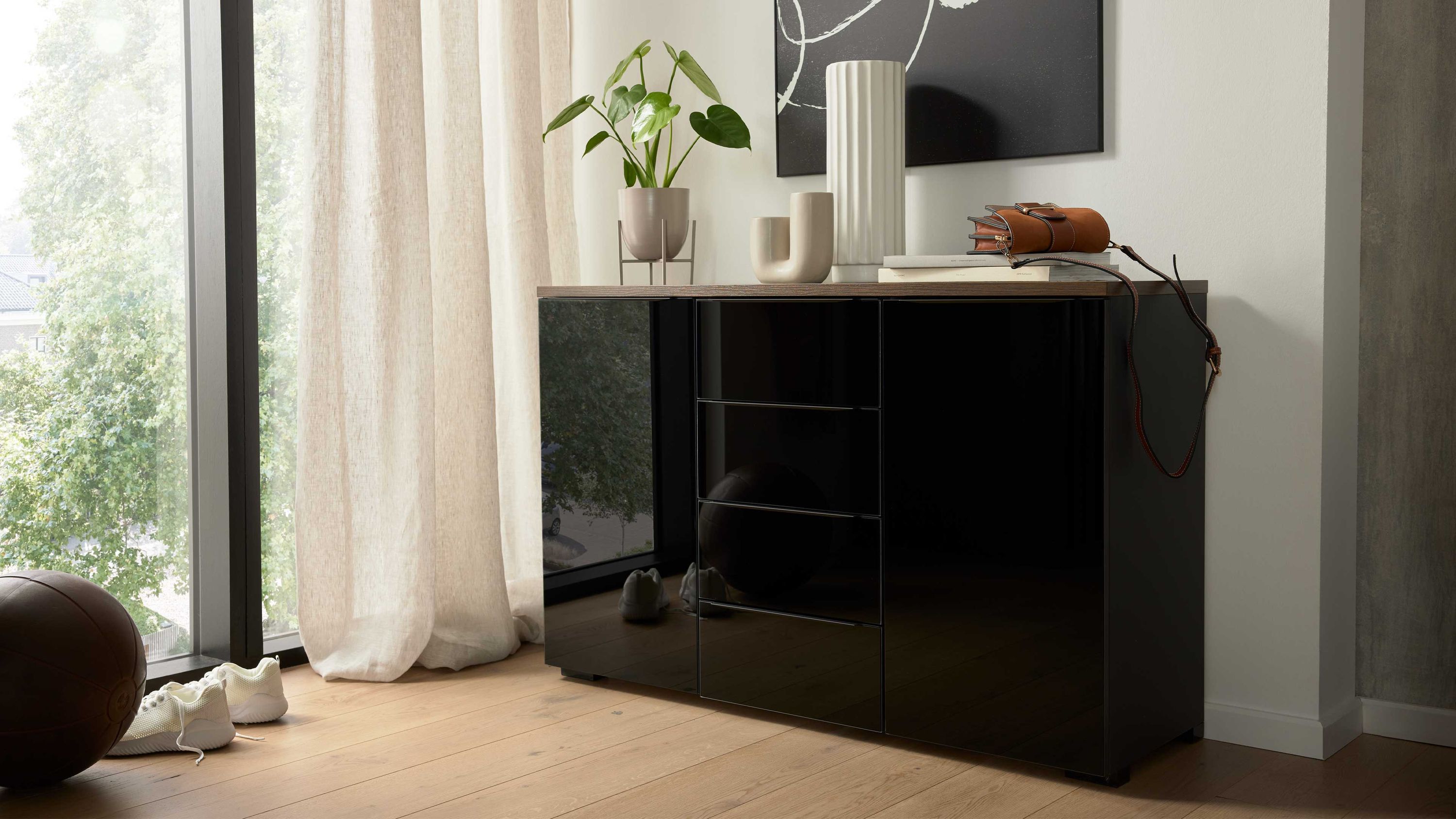Kombikommode mit zwei schwarzen Türen und vier schwarzen Schubladen Holzplatte in heller Farbe