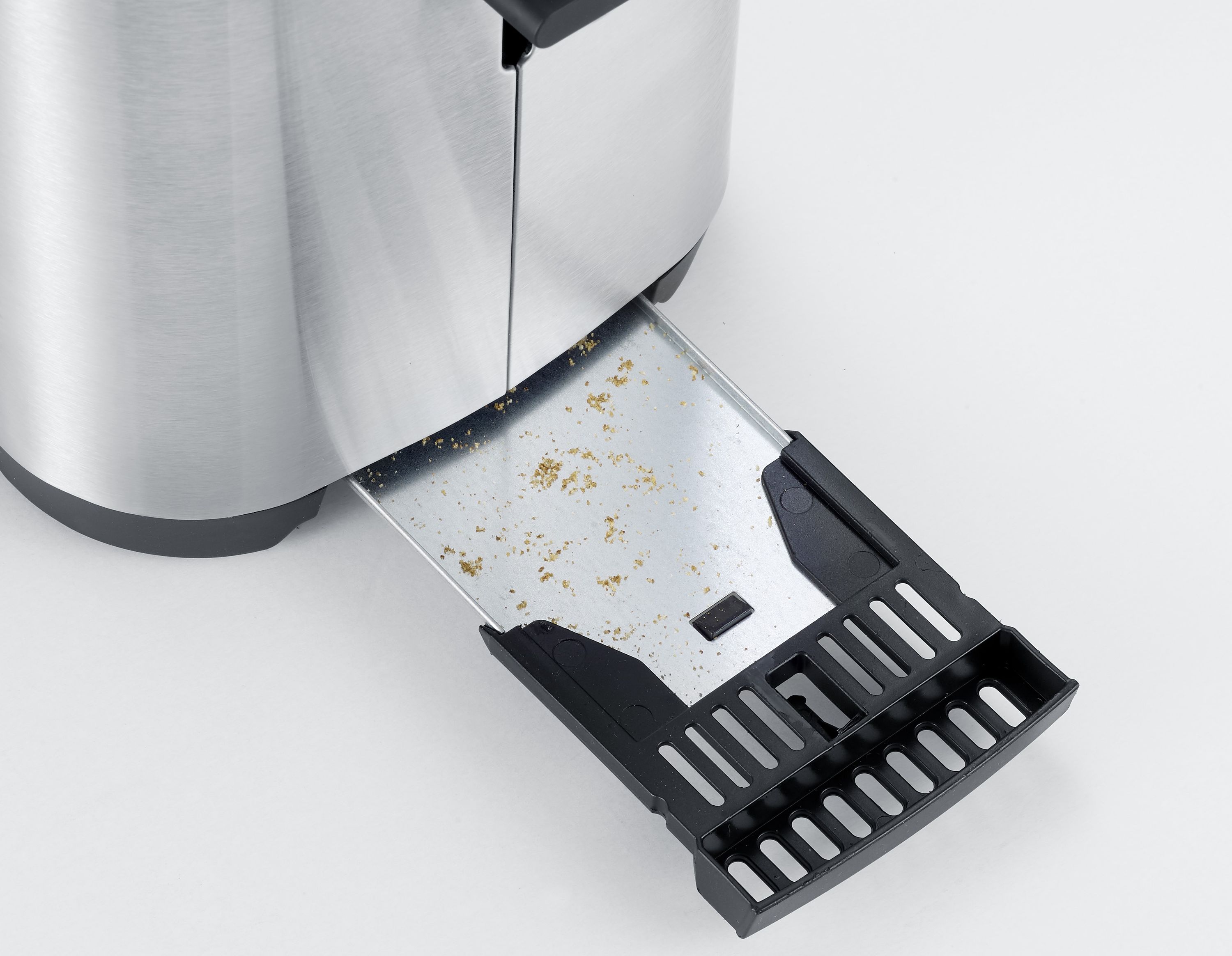 Edelstahl-Langschlitztoaster für vier Scheiben Fokus auf geöffneter Krümelschublade mit Krümeln schräg von oben links