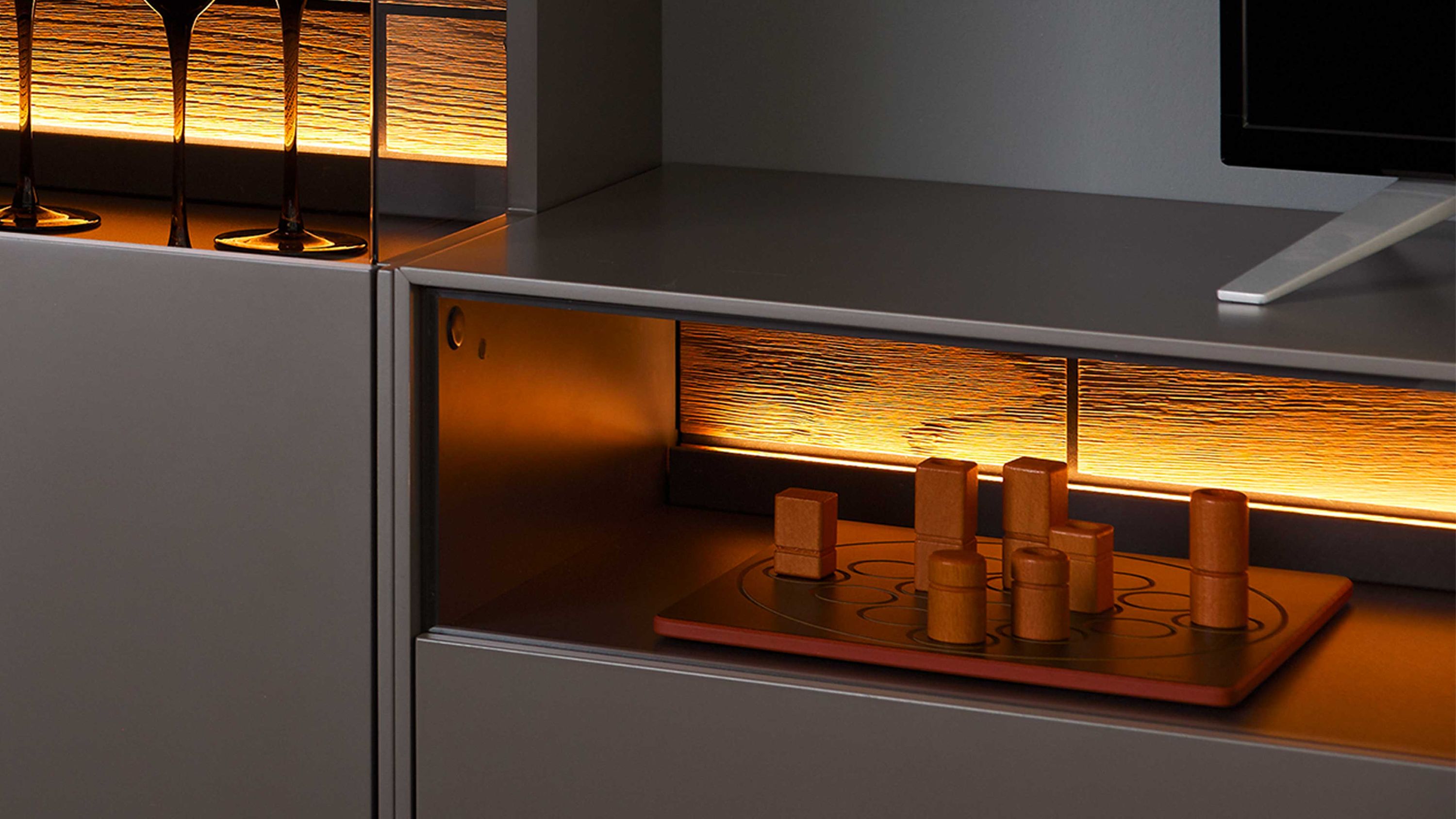 Zweiteilige LED-Beleuchtung in einem Wohnzimmerschrank mit glatter Oberfläche und warmem Licht