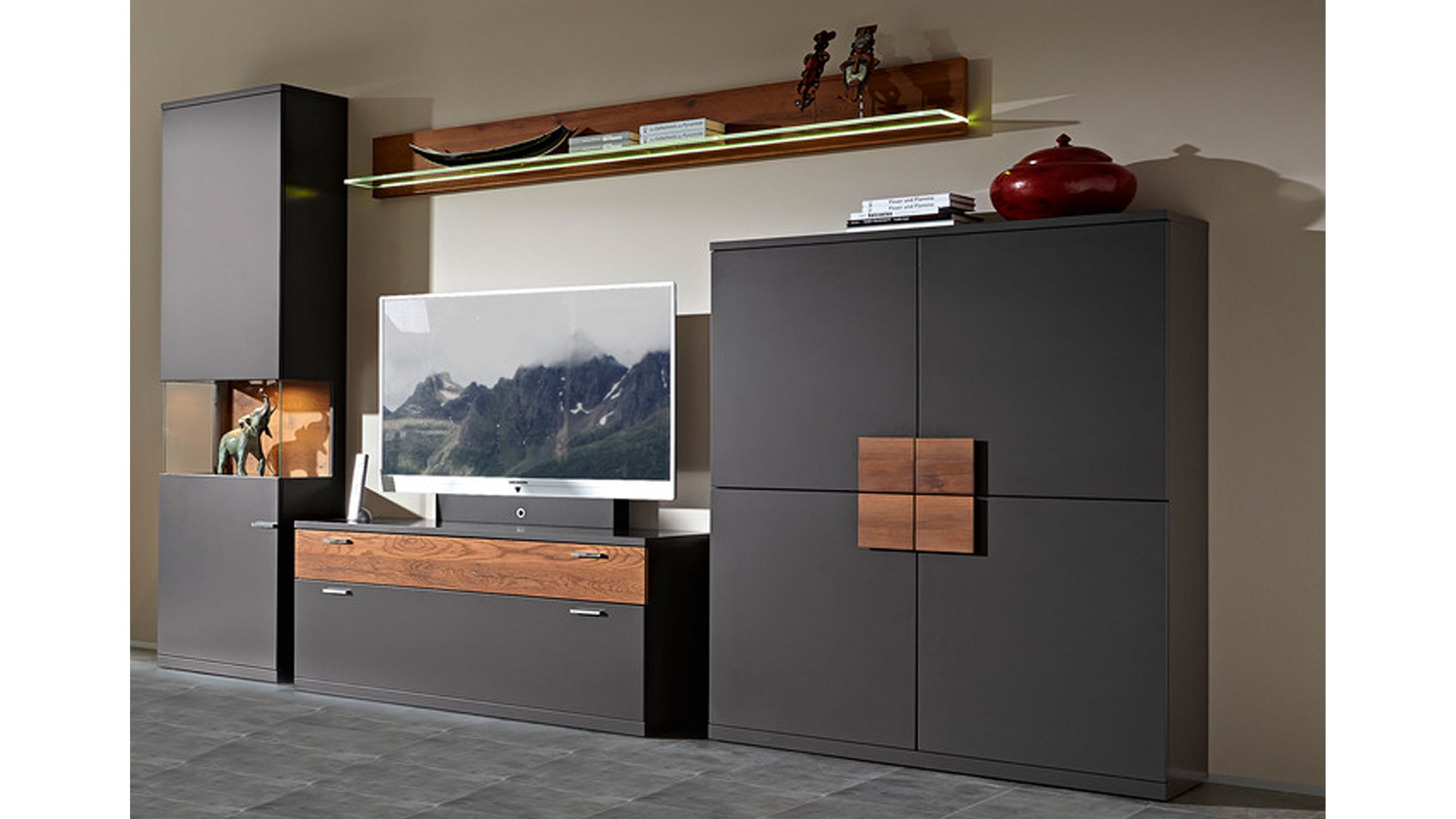 Wohnkombination mit graphitfarbenen Fronten Holzdetails und Glasablage an der Wand