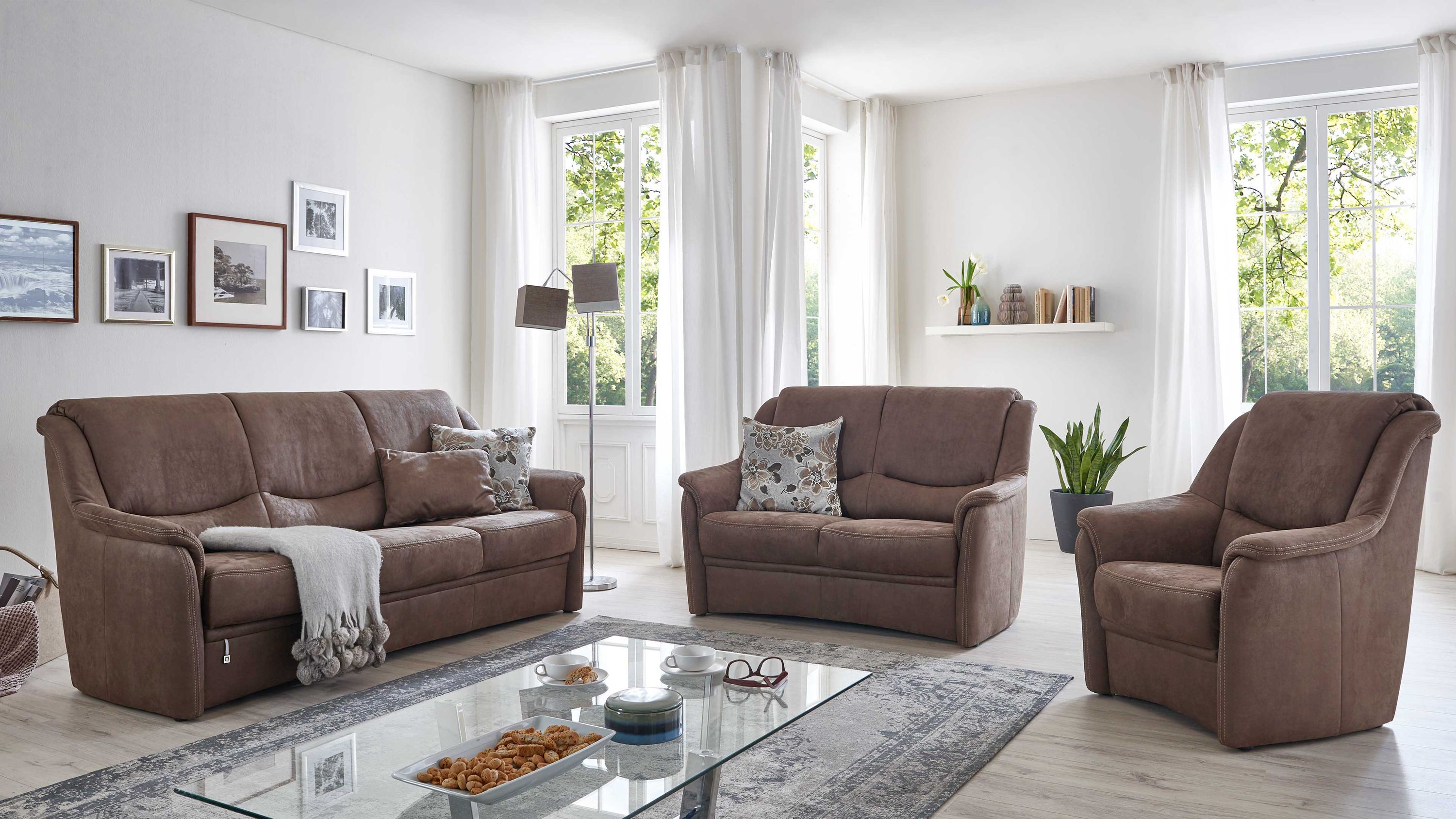 Dreiteilige Polstergarnitur mit zwei Sofas und einem Sessel in braunem Stoff in hellem Wohnzimmer