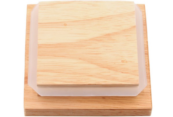 Quadratische Holzbretter Ein quadratisches Holzbrett mit abgerundeten Ecken, das auf einem weiteren quadratischen Holzbrett liegt