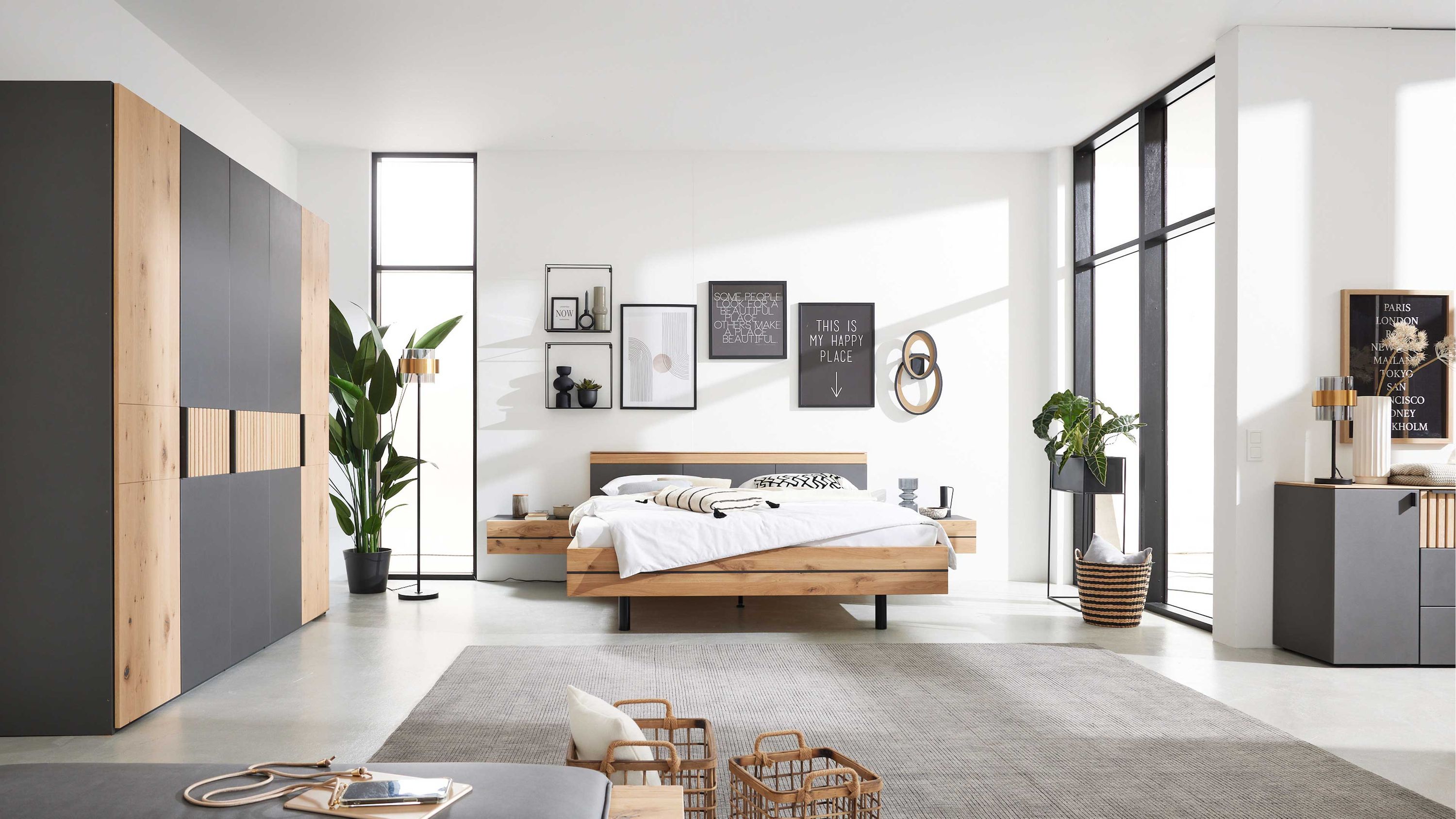 Schlafzimmer mit Kleiderschrank Bett und Nachttischen in Holz und Dunkelgrau Schlafzimmer mit fünftürigem Kleiderschrank Bett mit Kopfteil und zwei hängenden Nachttischen in Holz- und dunkler Farbe