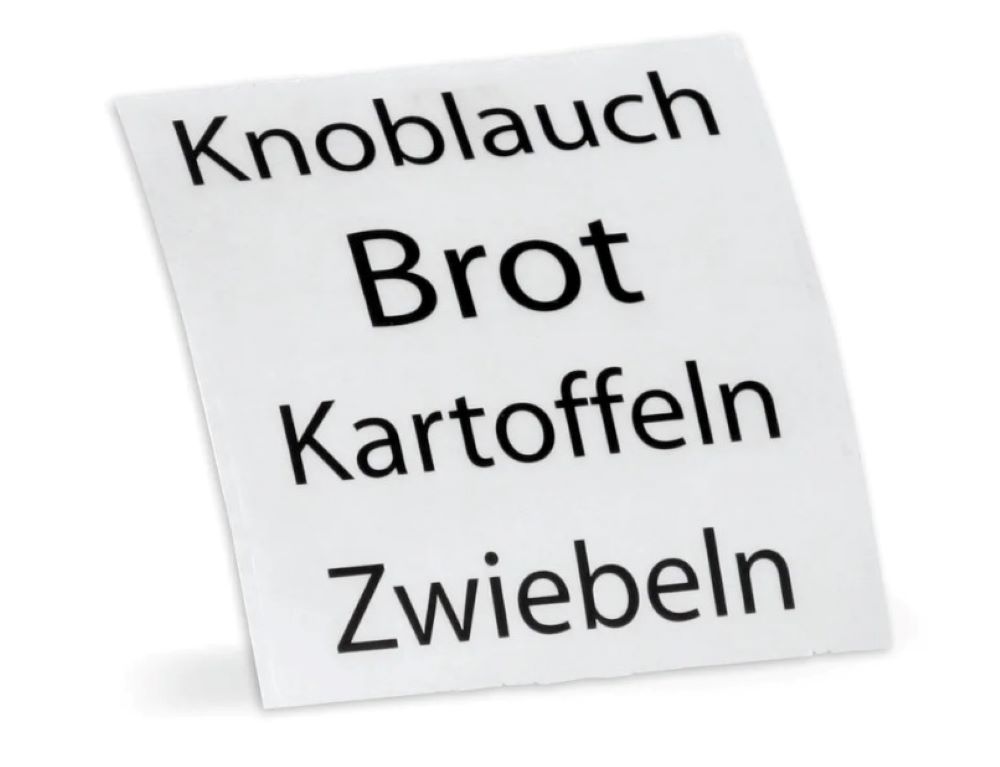Perspektivische Ansicht eines weißen Blatts mit den Wörtern Knoblauch, Brot, Kartoffeln und Zwiebeln.