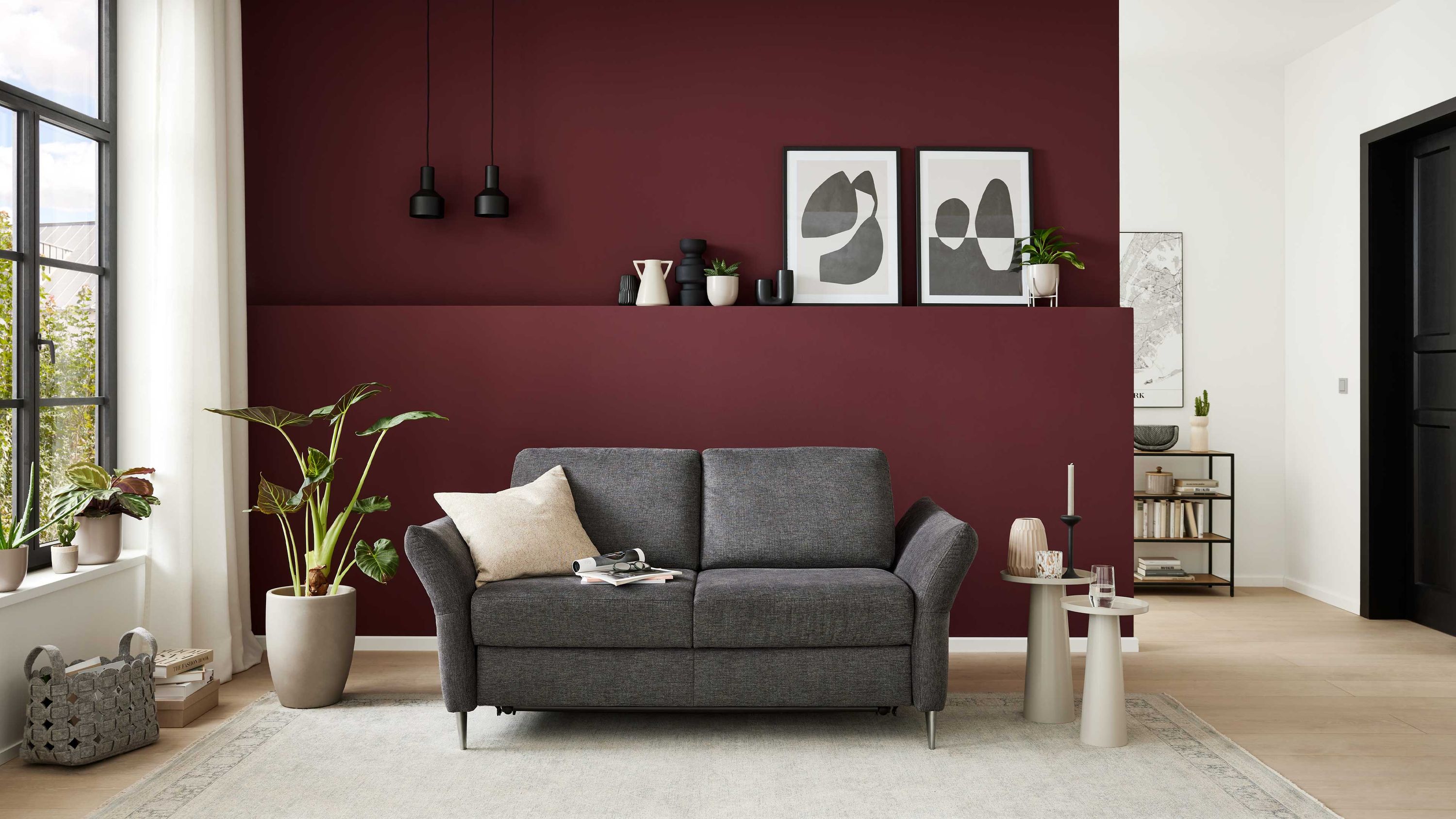 Anthrazitfarbenes Schlafsofa mit zwei Sitzkissen und Metallfüßen in modernem Wohnzimmer