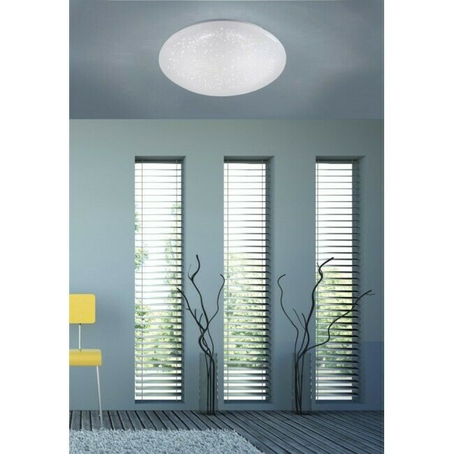 Runde LED-Deckenleuchte mit Sternenhimmel-Effekt in modernem Wohnraum mit hohen Fenstern und grauer Decke
