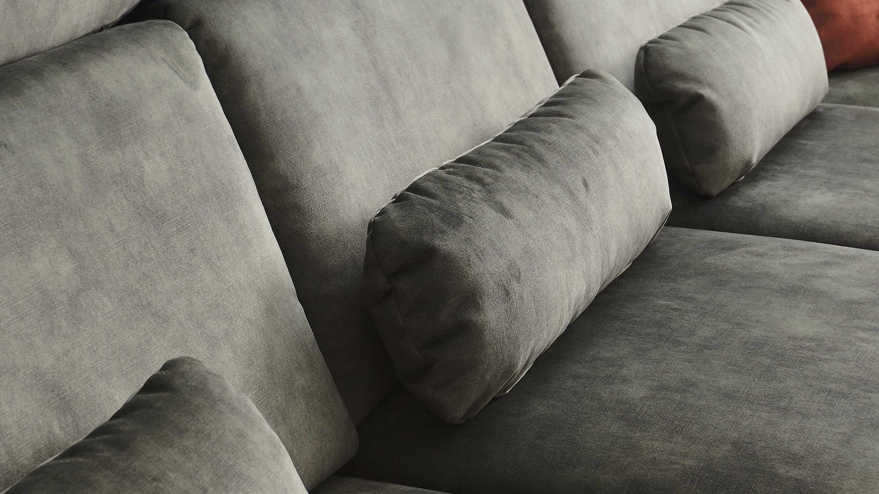 Moosgrünes Nierenkissen aus Velours auf einem Sofa