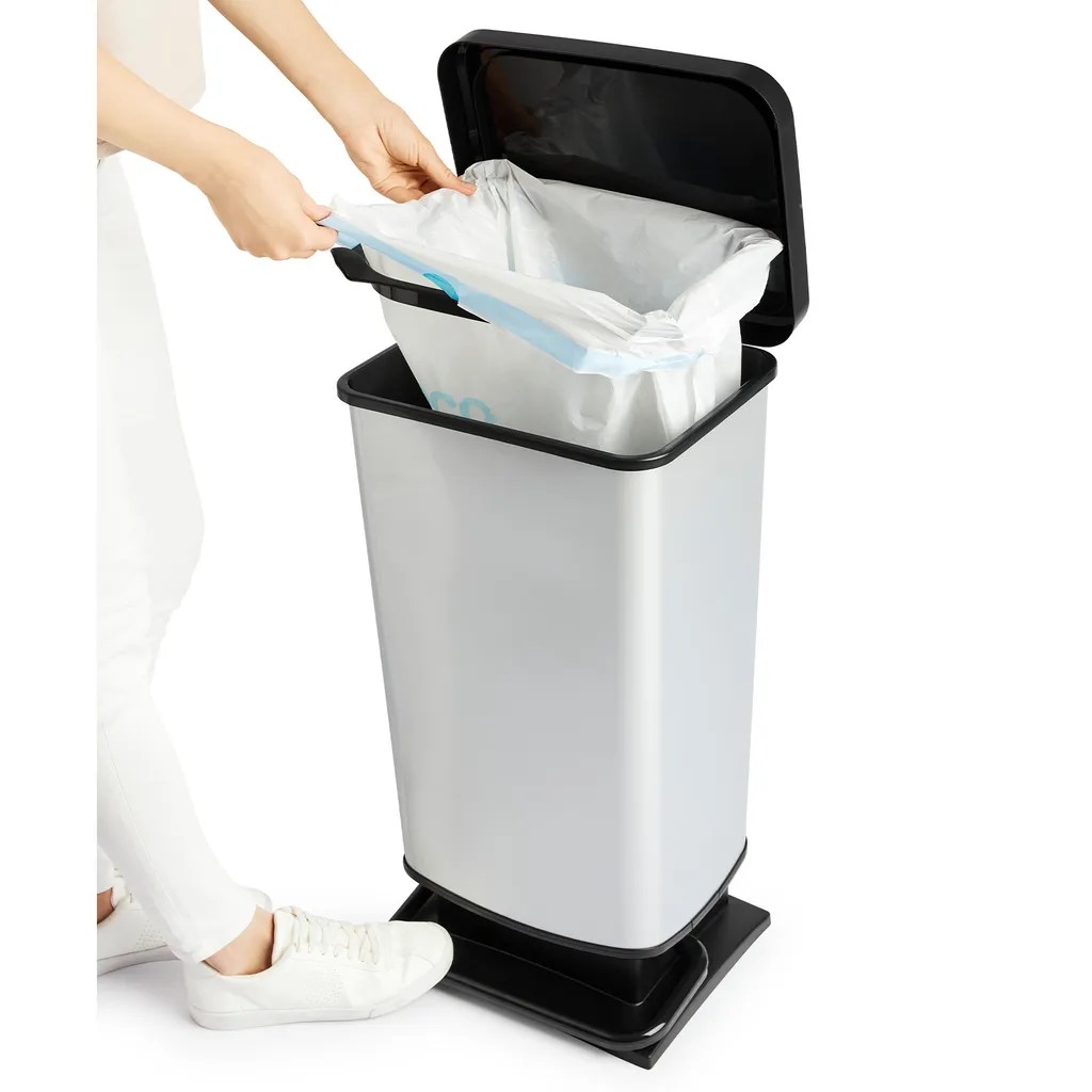 Silberner Treteimer Paso mit geöffnetem Deckel Treteimer Paso silber rechteckig Deckel geöffnet Person legt Müllbeutel ein leicht erhöht fotografiert