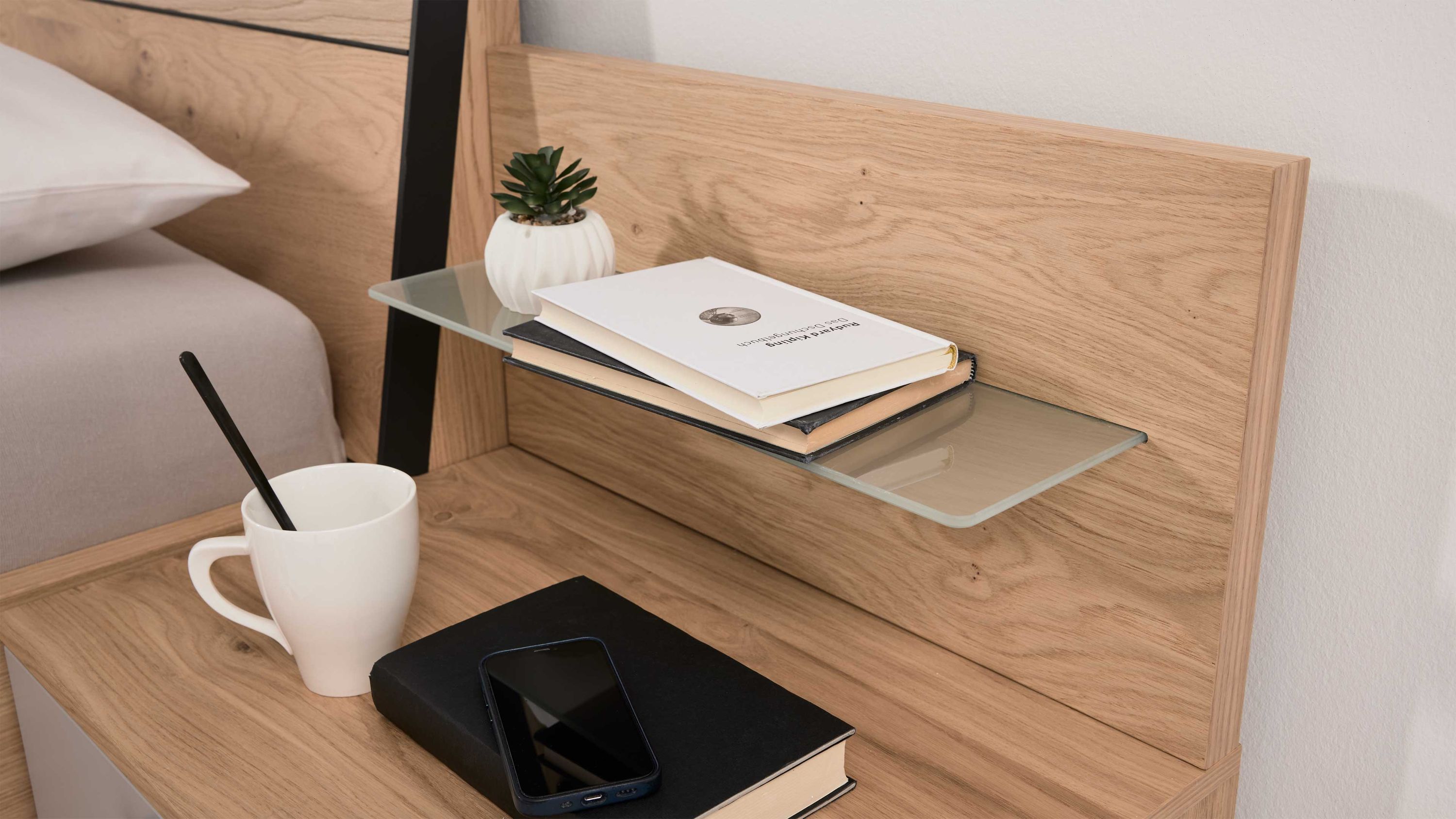 Paneelaufsatz aus Holz mit einer Glasablage darauf Bücher und eine kleine Pflanze