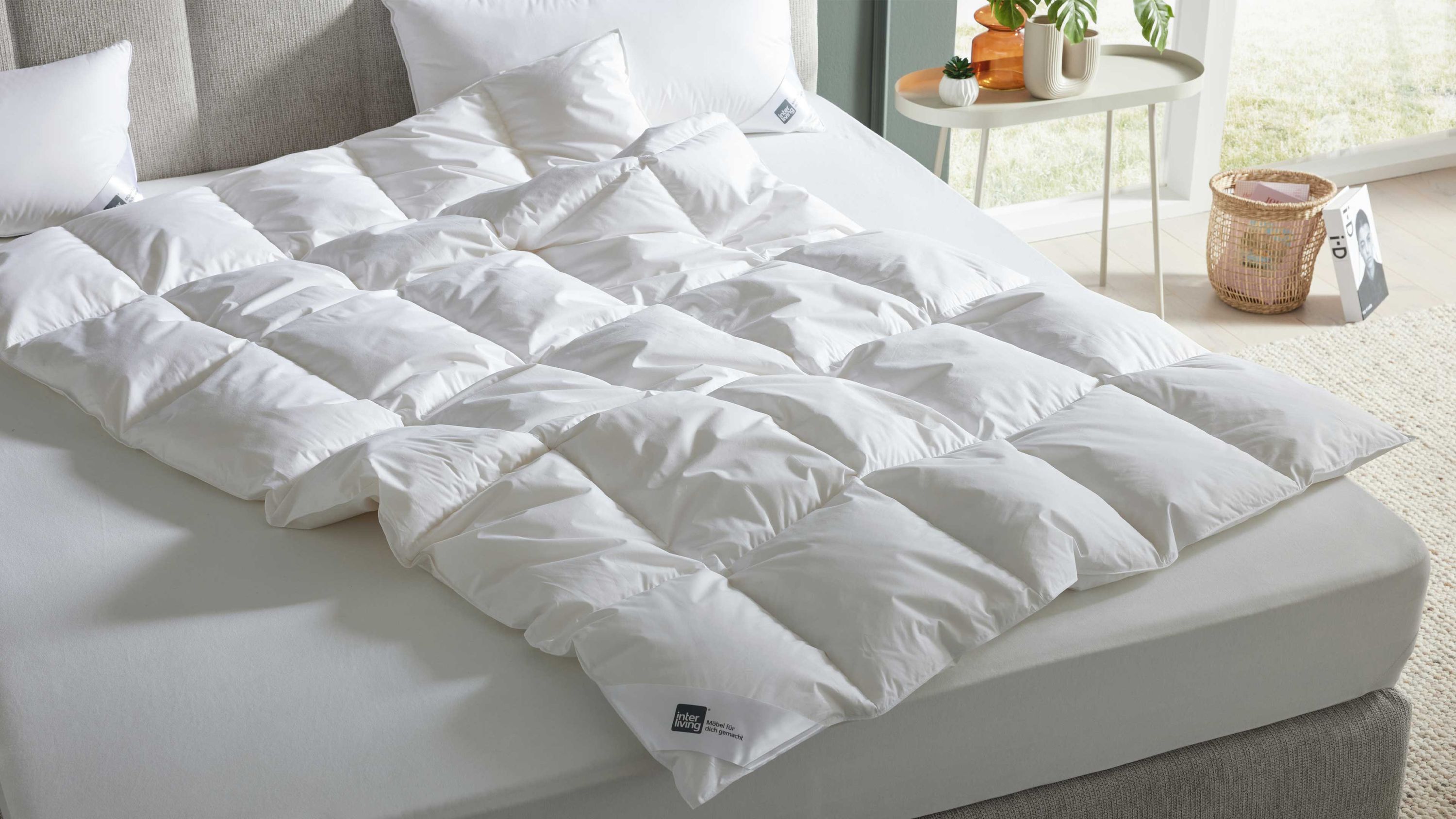 Weiße Cassettendecke mit quadratischen Steppungen auf einem Bett mit grauem Kopfteil